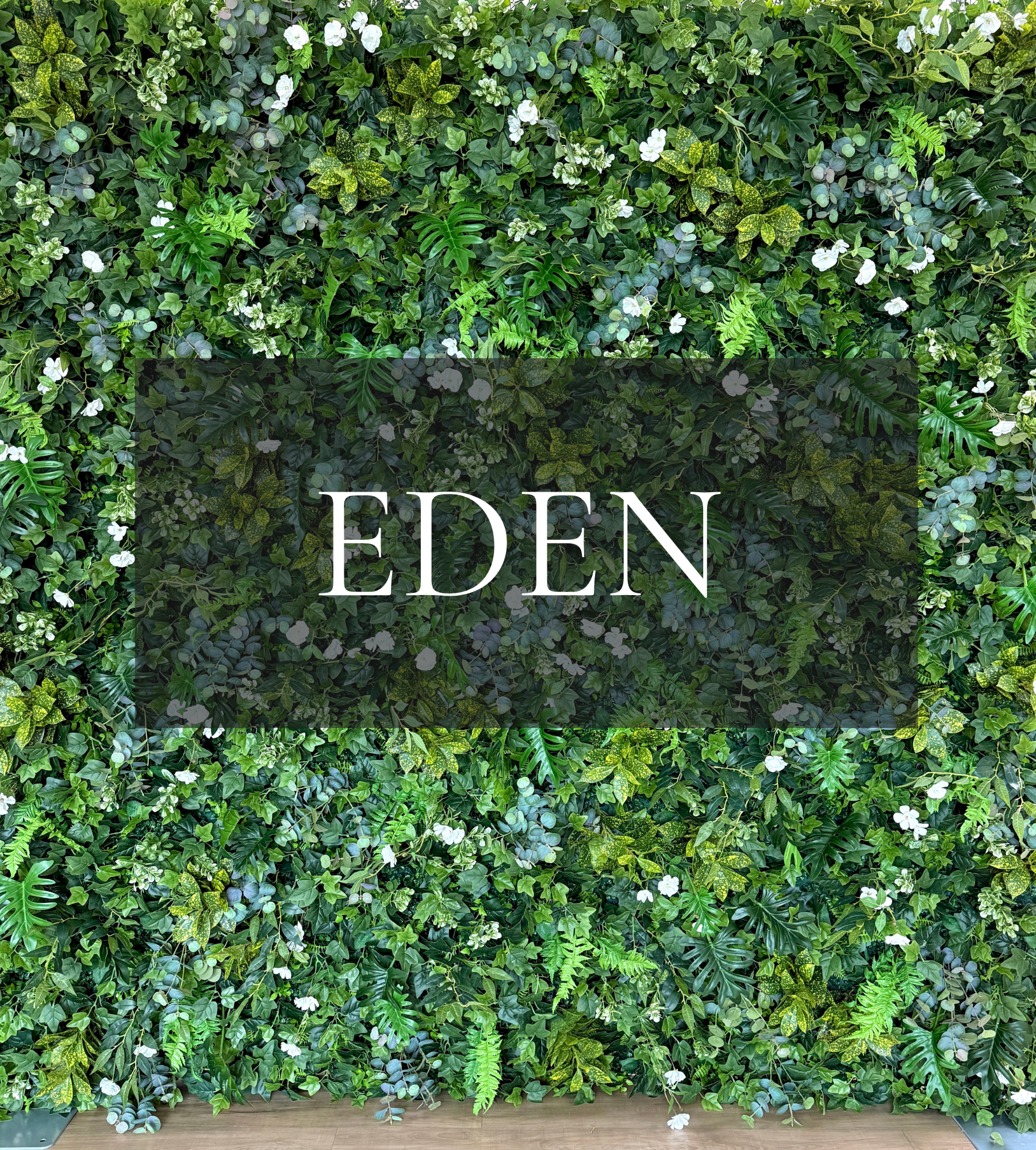 Rich mixed greenery, layered tropical leaves, scattered white blooms.