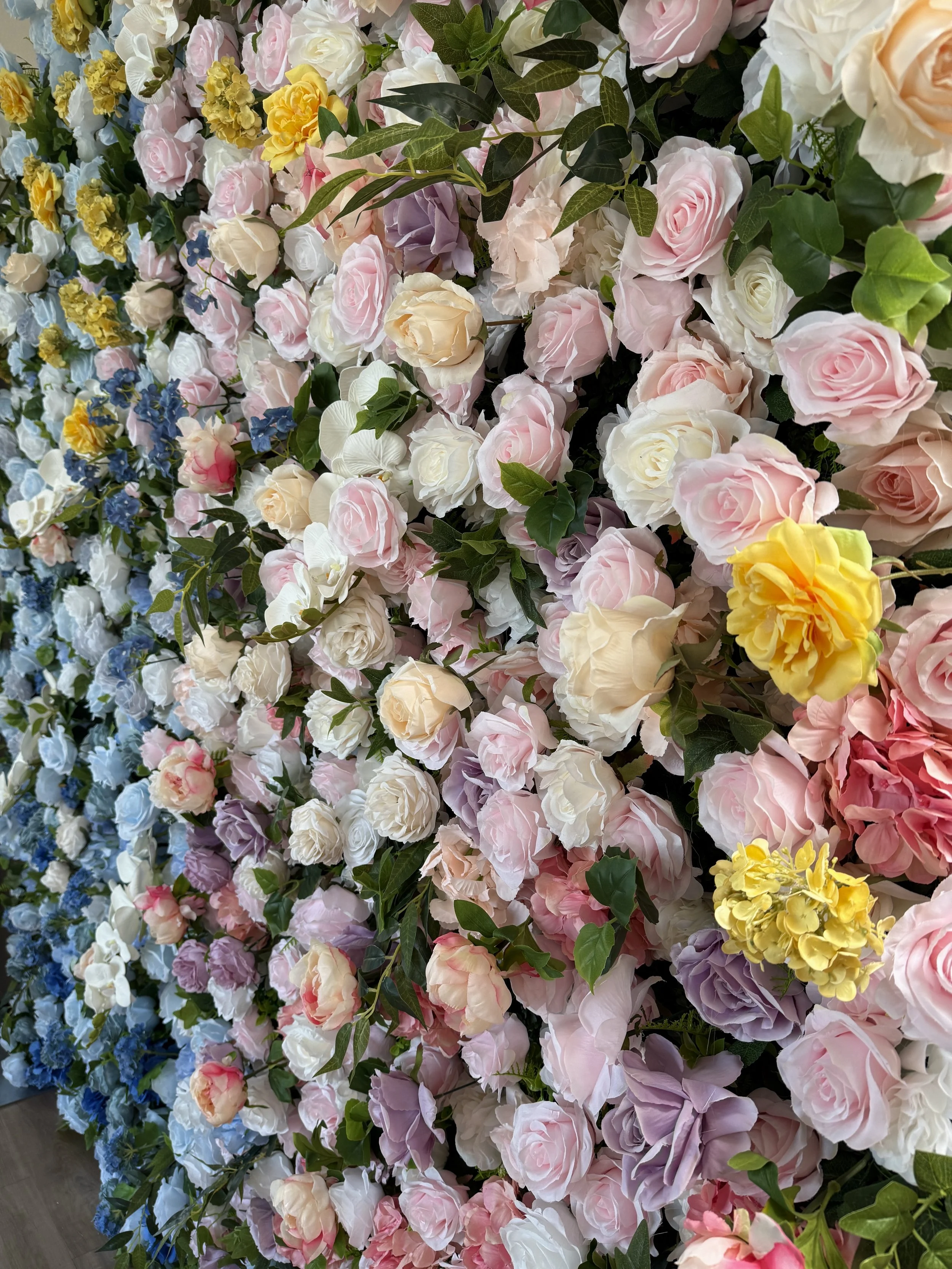 Blue, lavender and blush roses, blue hydrangeas, white orchids, golden blooms, lush greenery.