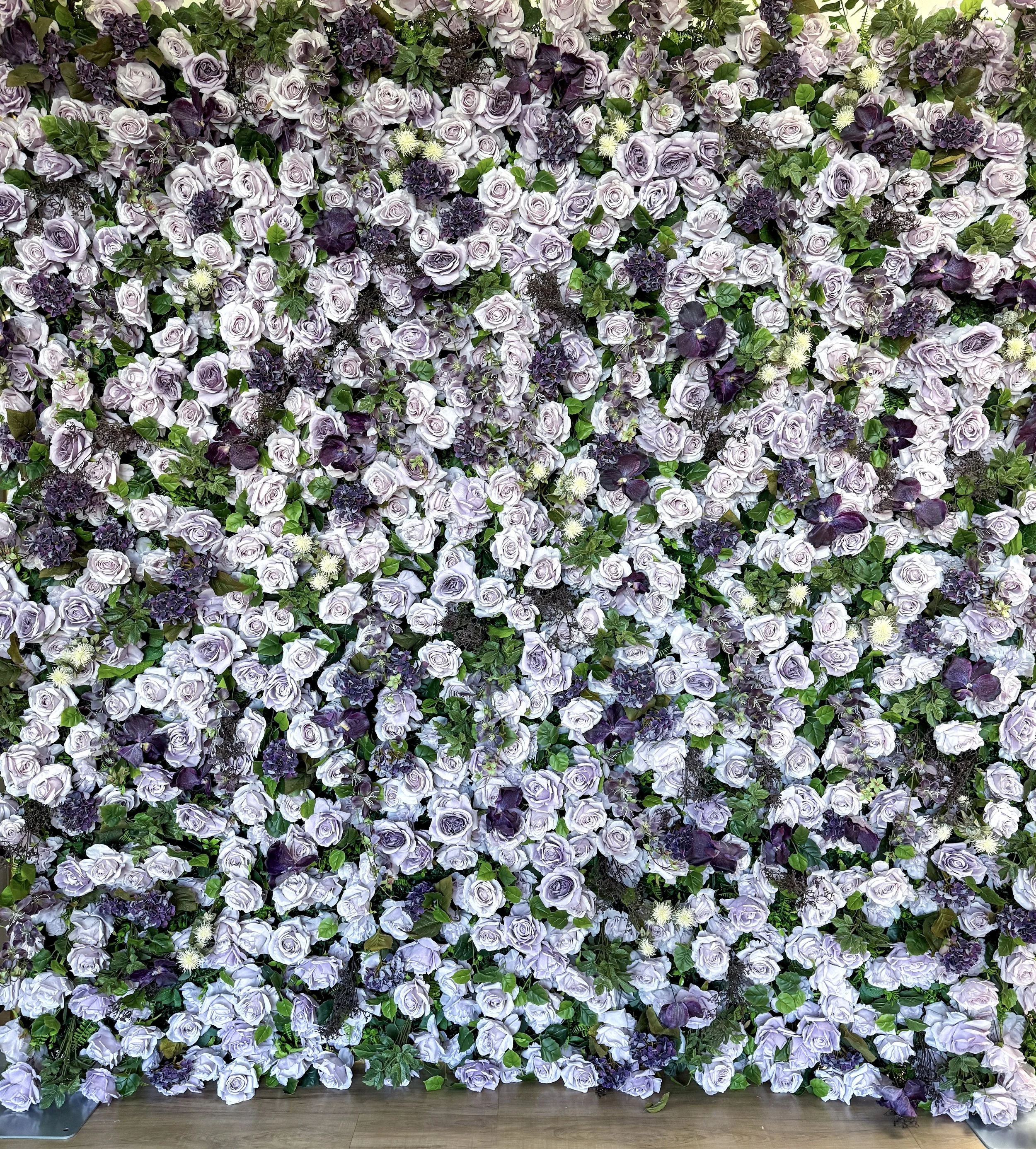 Soft lavender and mauve roses, deep plum blooms, lush green foliage.