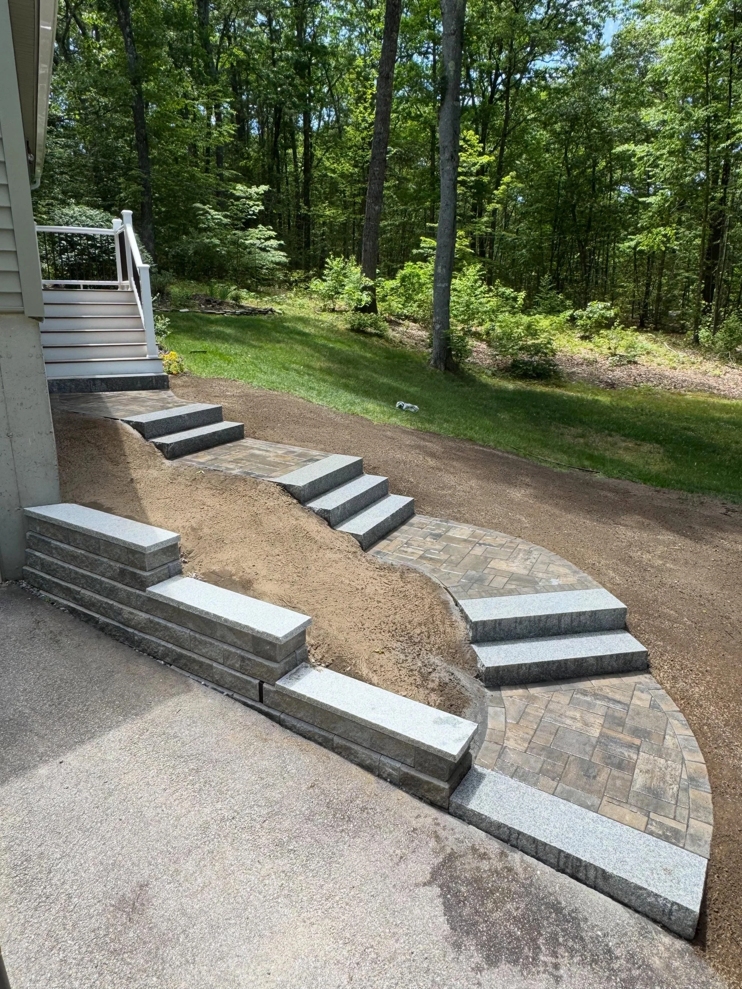 See this custom retaining wall and paver walkway in Chester, NH built with Unilock Treo Premier pavers, Concord wall block, and granite caps for lasting curb appeal.