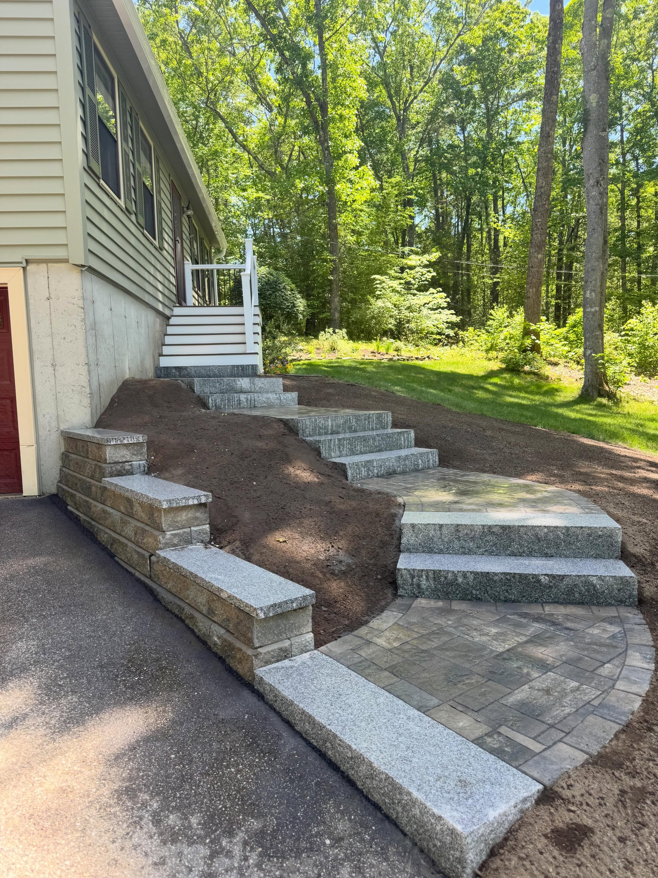 Completed hardscape project in Chester, NH featuring a Unilock Treo Premier paver walkway, Concord retaining wall, granite caps, and granite steps by KG Stone & Hardscape LLC.