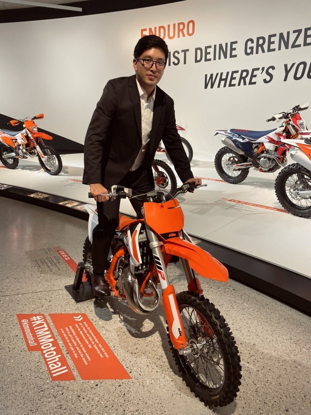 邑舶貿易創辦人 Jacob Lee 於 KTM 展示車旁