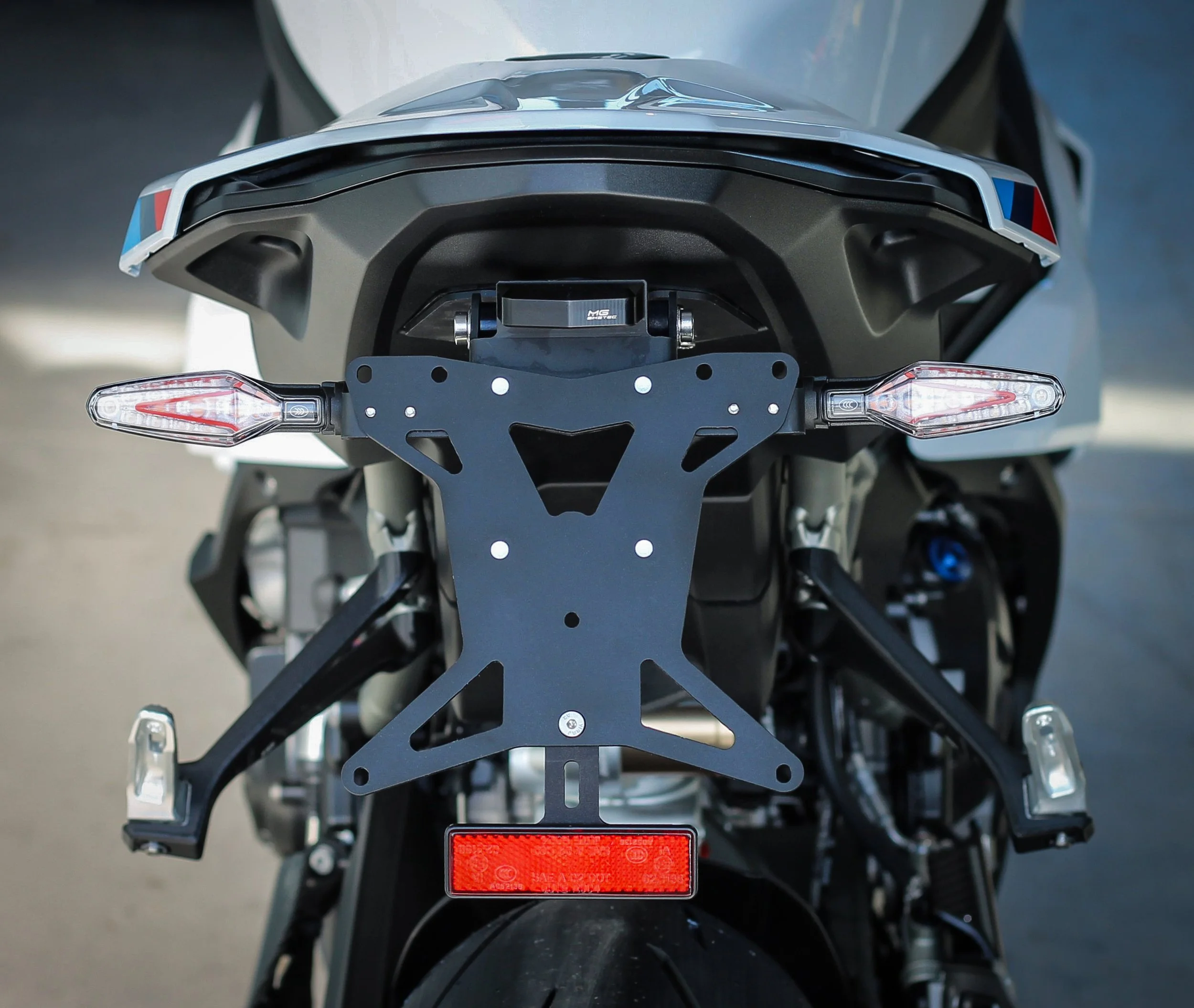 Rear view of a motorcycle with turn signals and a license plate holder.
