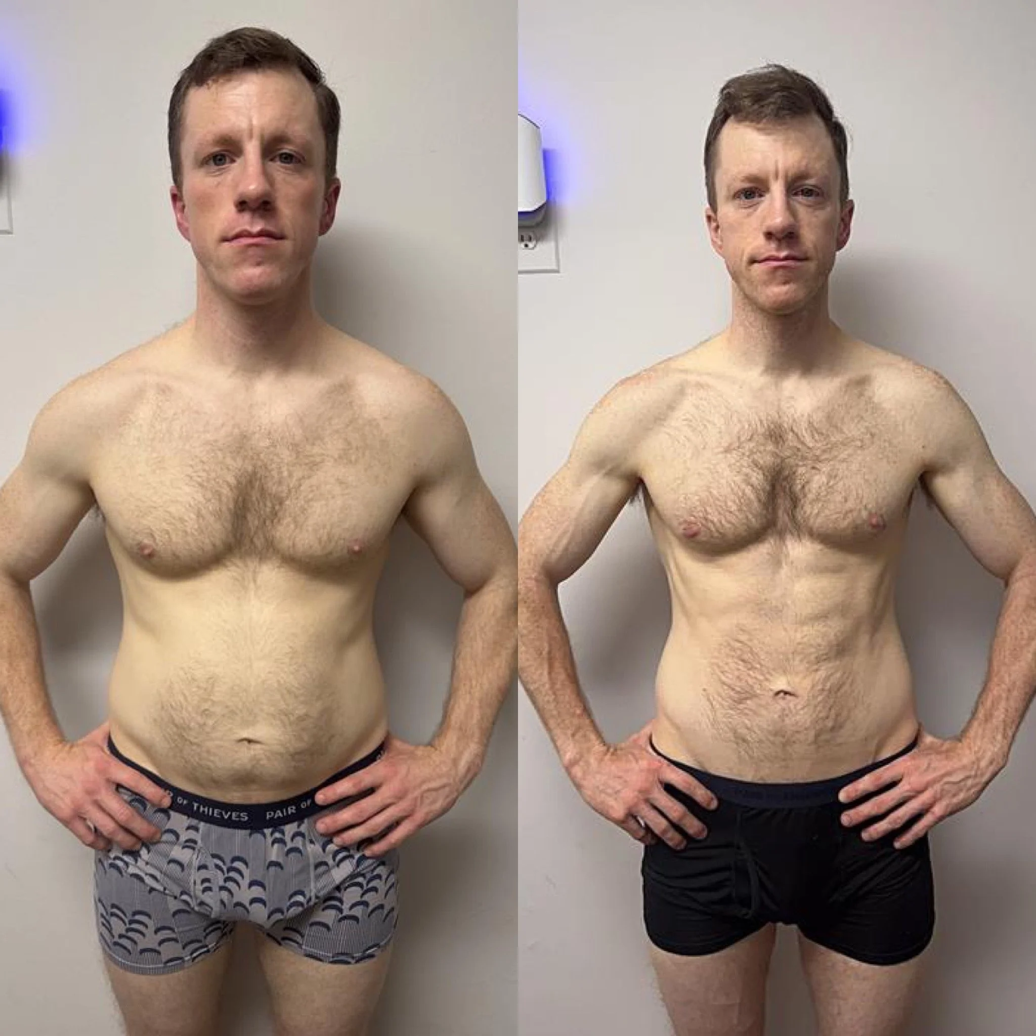 Two shirtless men standing side by side against a plain wall. The man on the left is wearing patterned boxer shorts, and the man on the right is wearing black boxer briefs. Both have similar hair and skin tone.