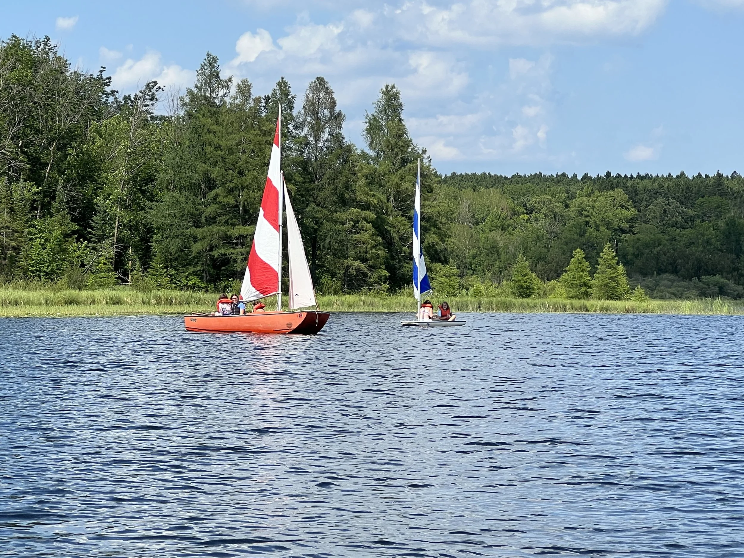 Two sailboats sailing on private lake.