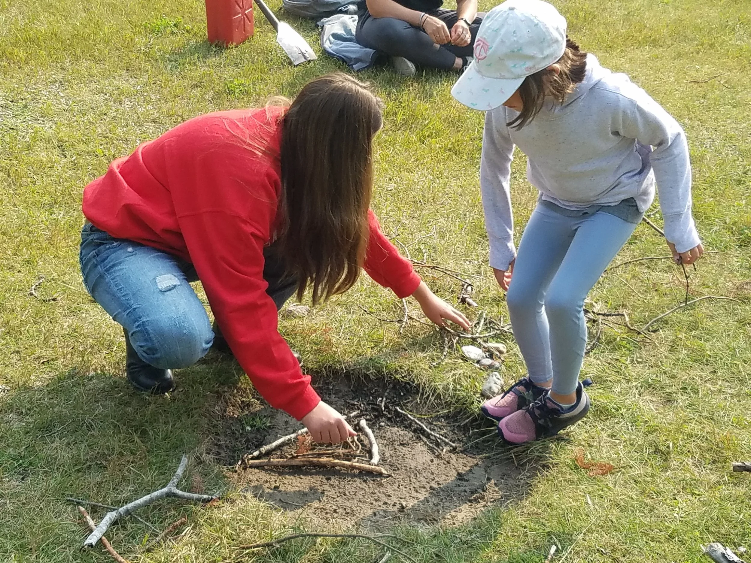 Two girls building a-frame fire