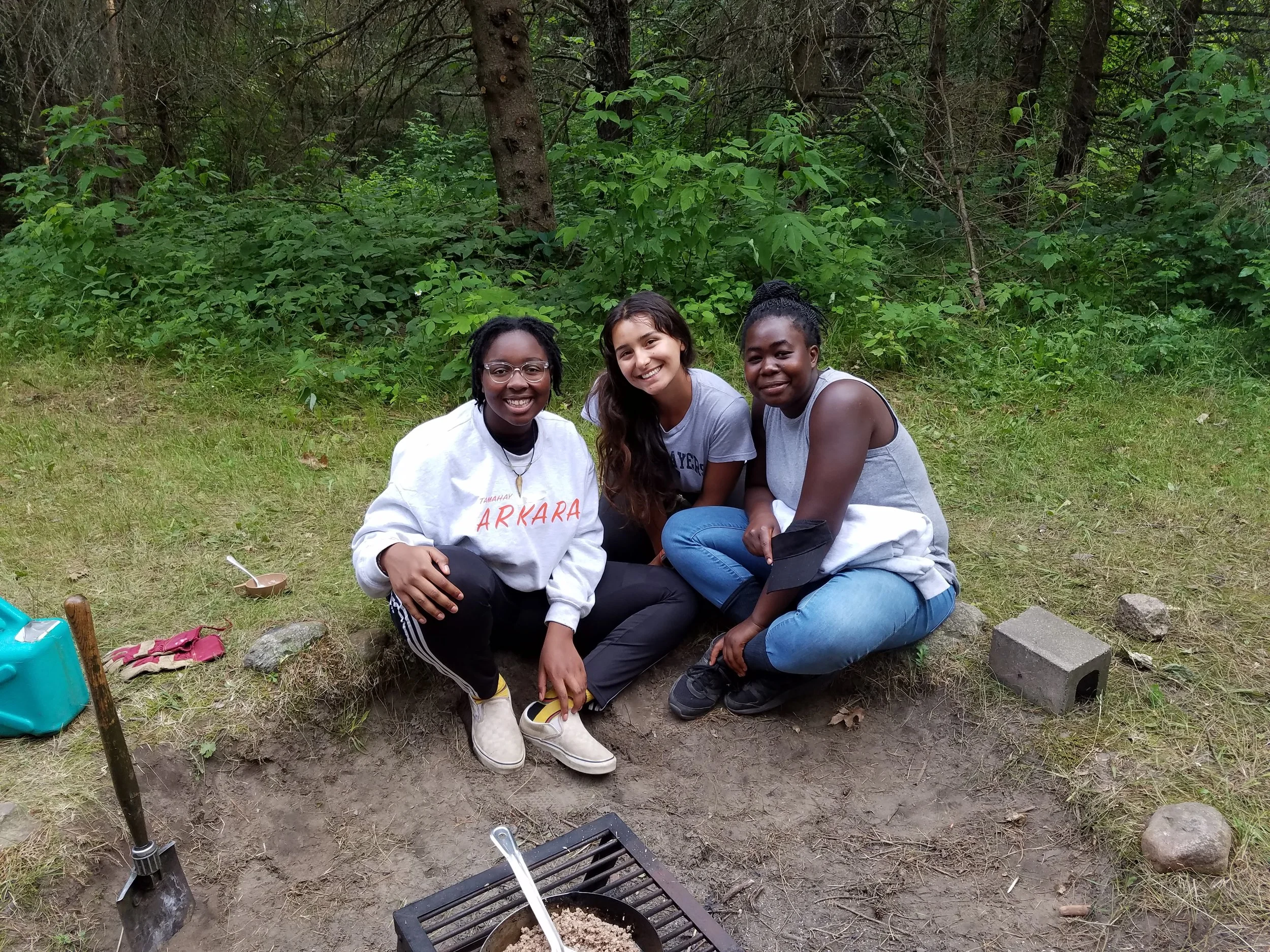 Three counselors sitting at cookout site