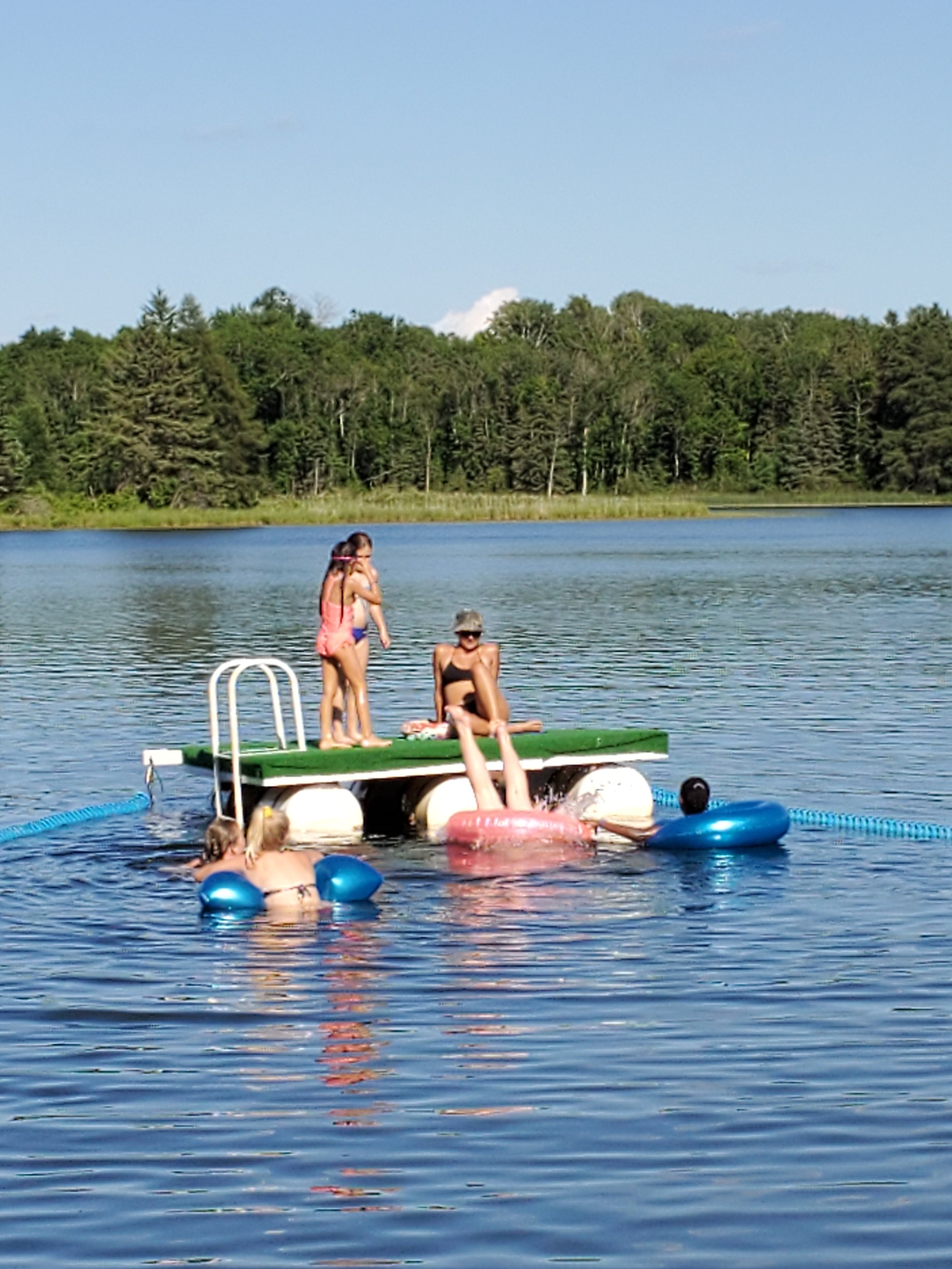 Girl diving off raft through inner tube