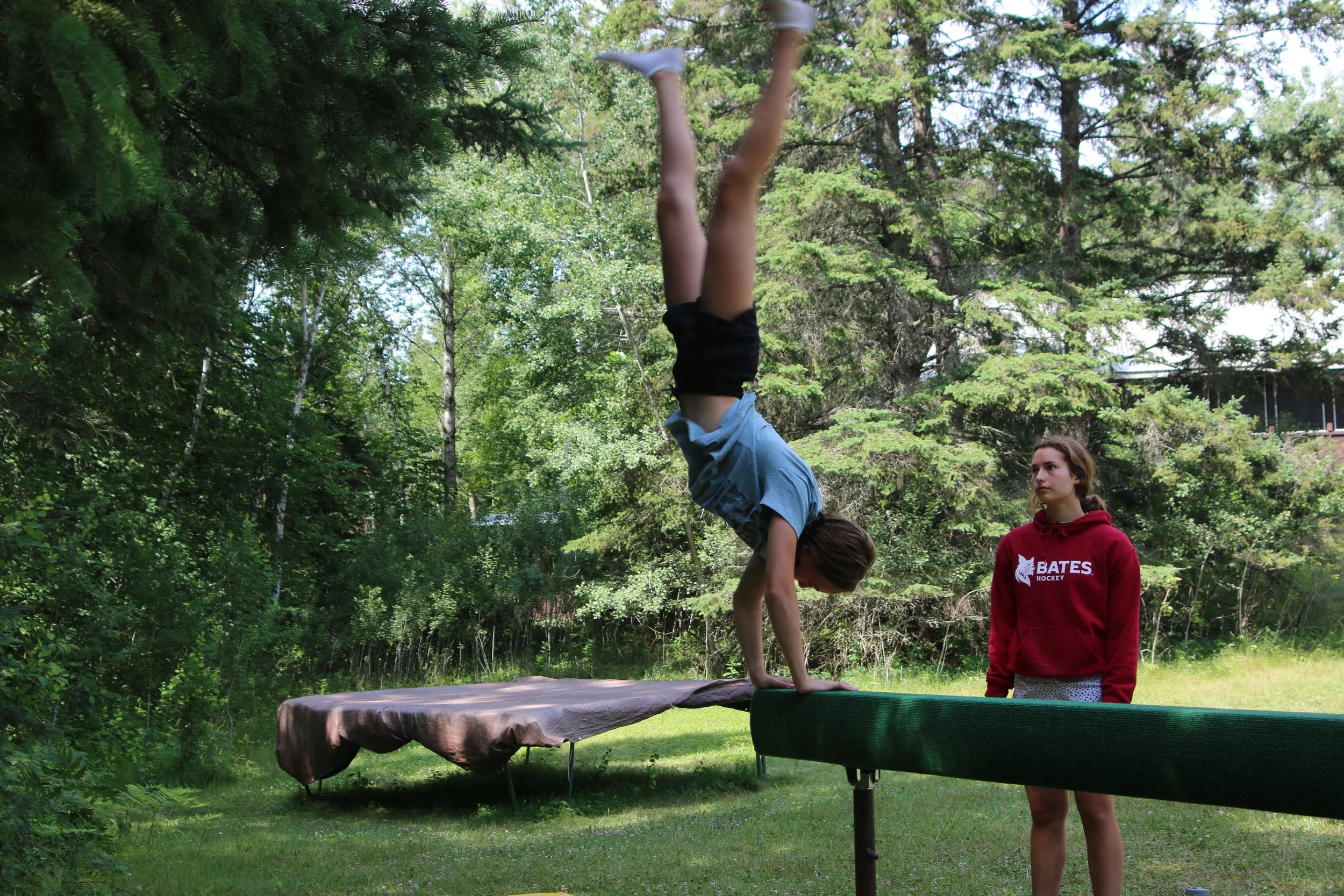 Girl summersaults off balance beam