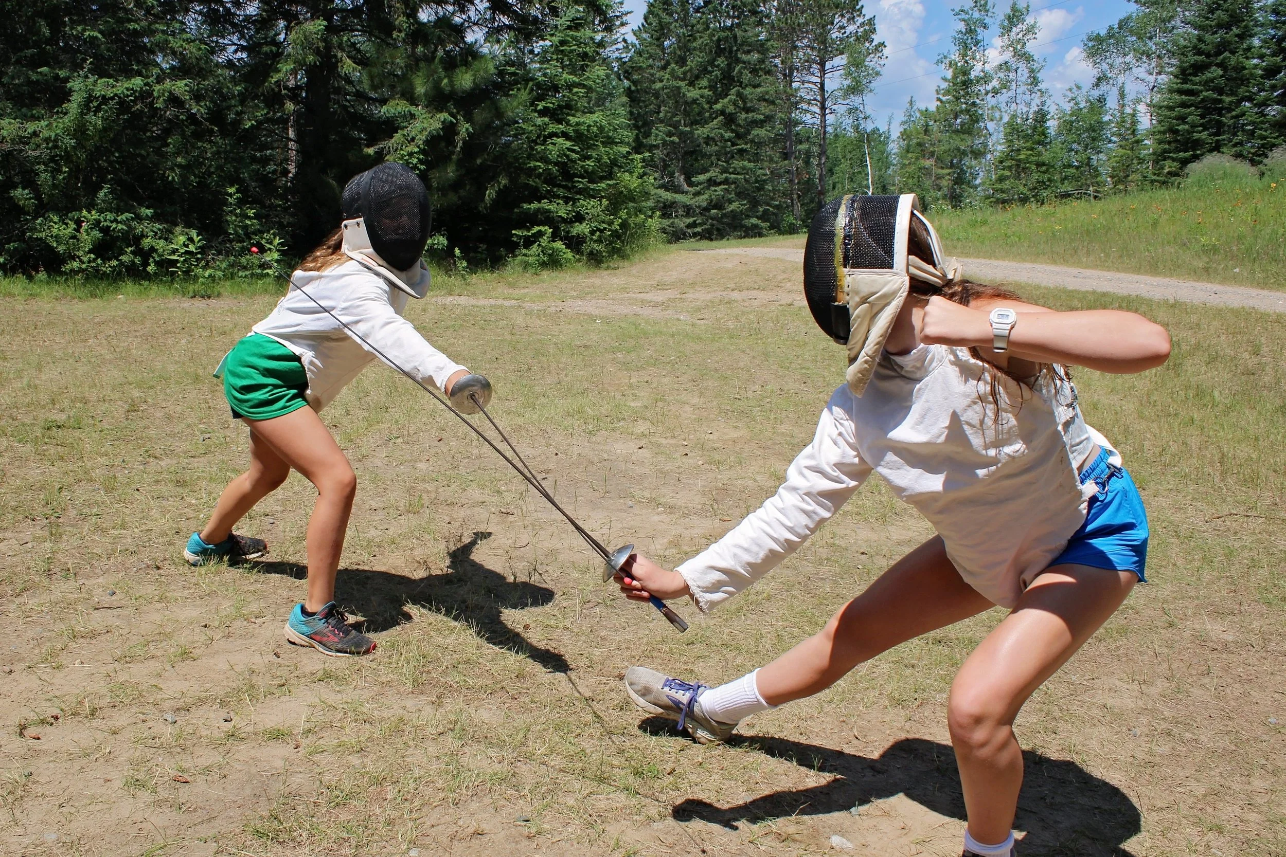 Two girls fencing, one using a parry other lunging