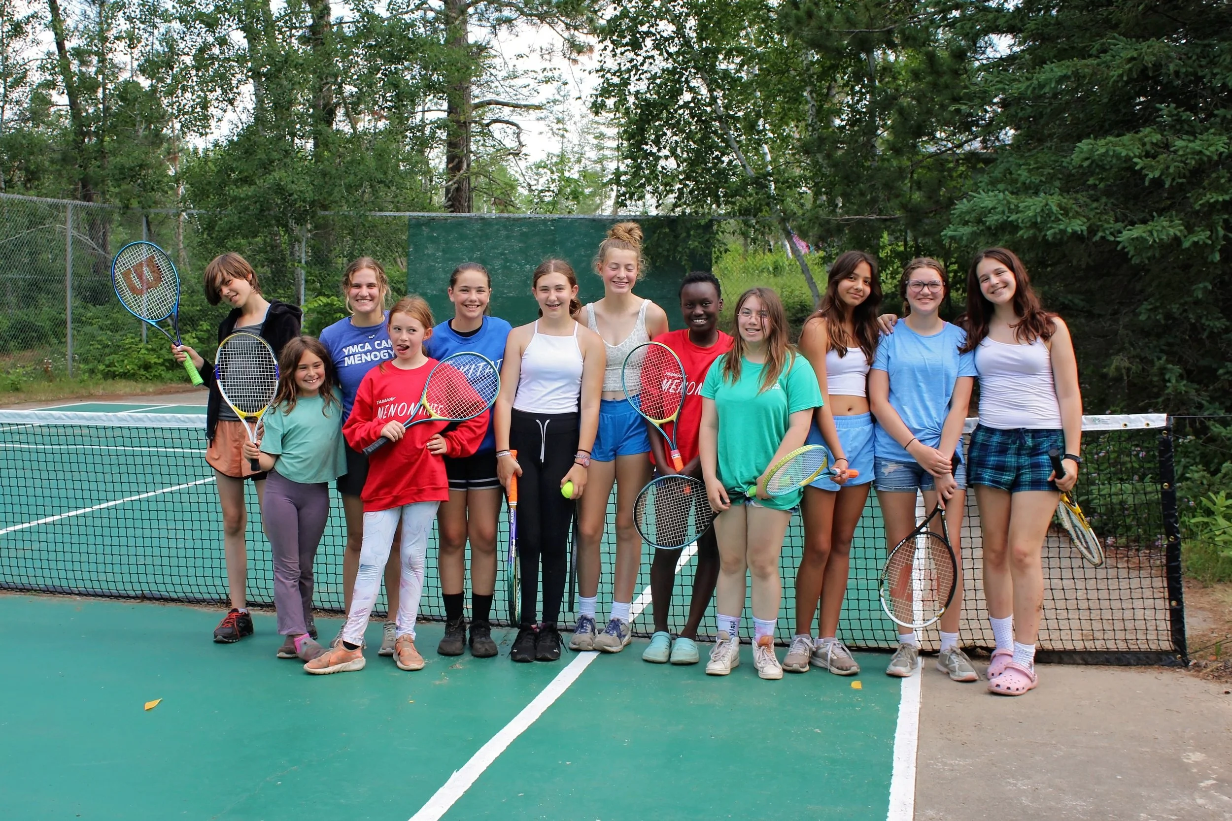 Tennis class with rackets on tennis court.