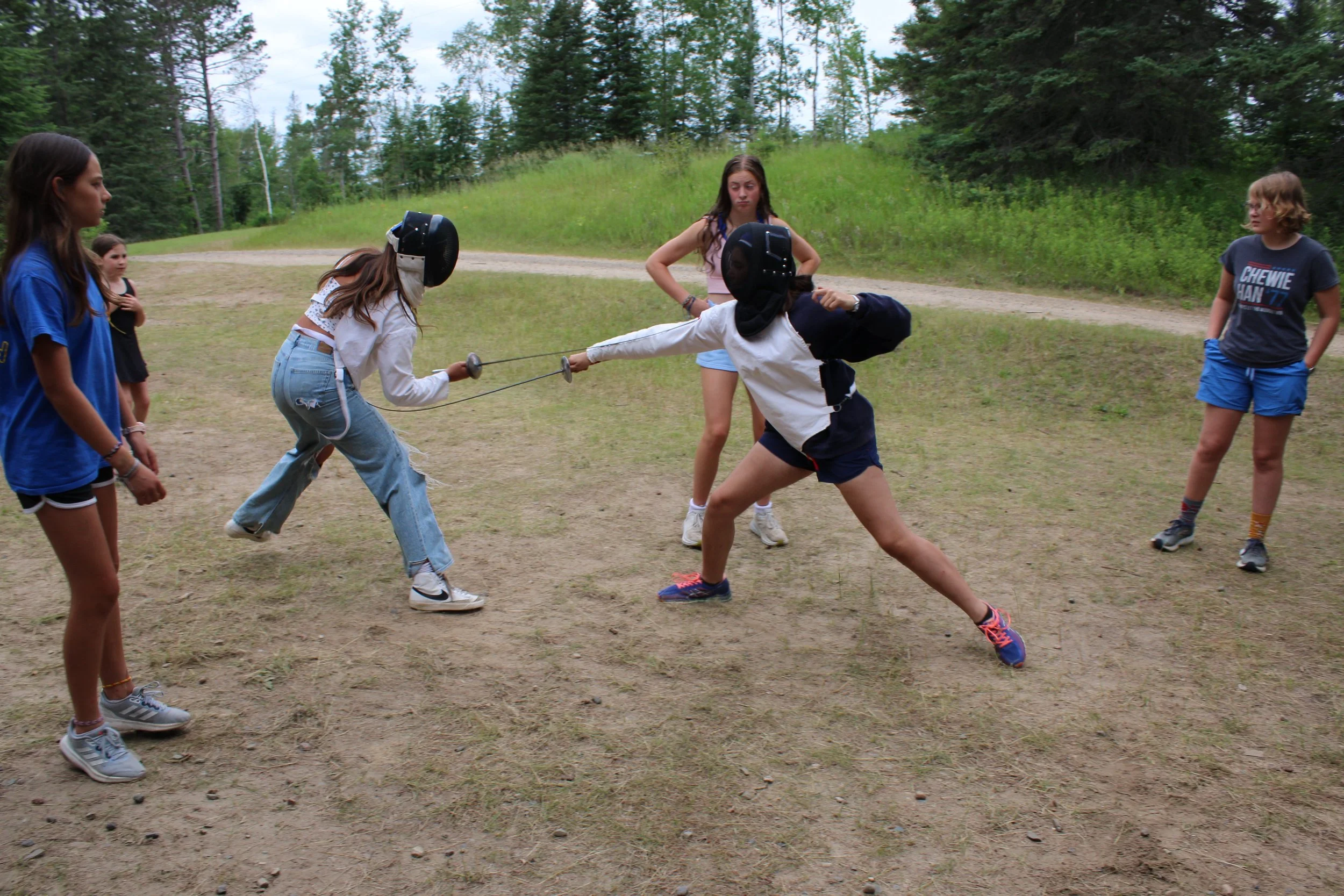 Girls fencing using a lunge and parry.