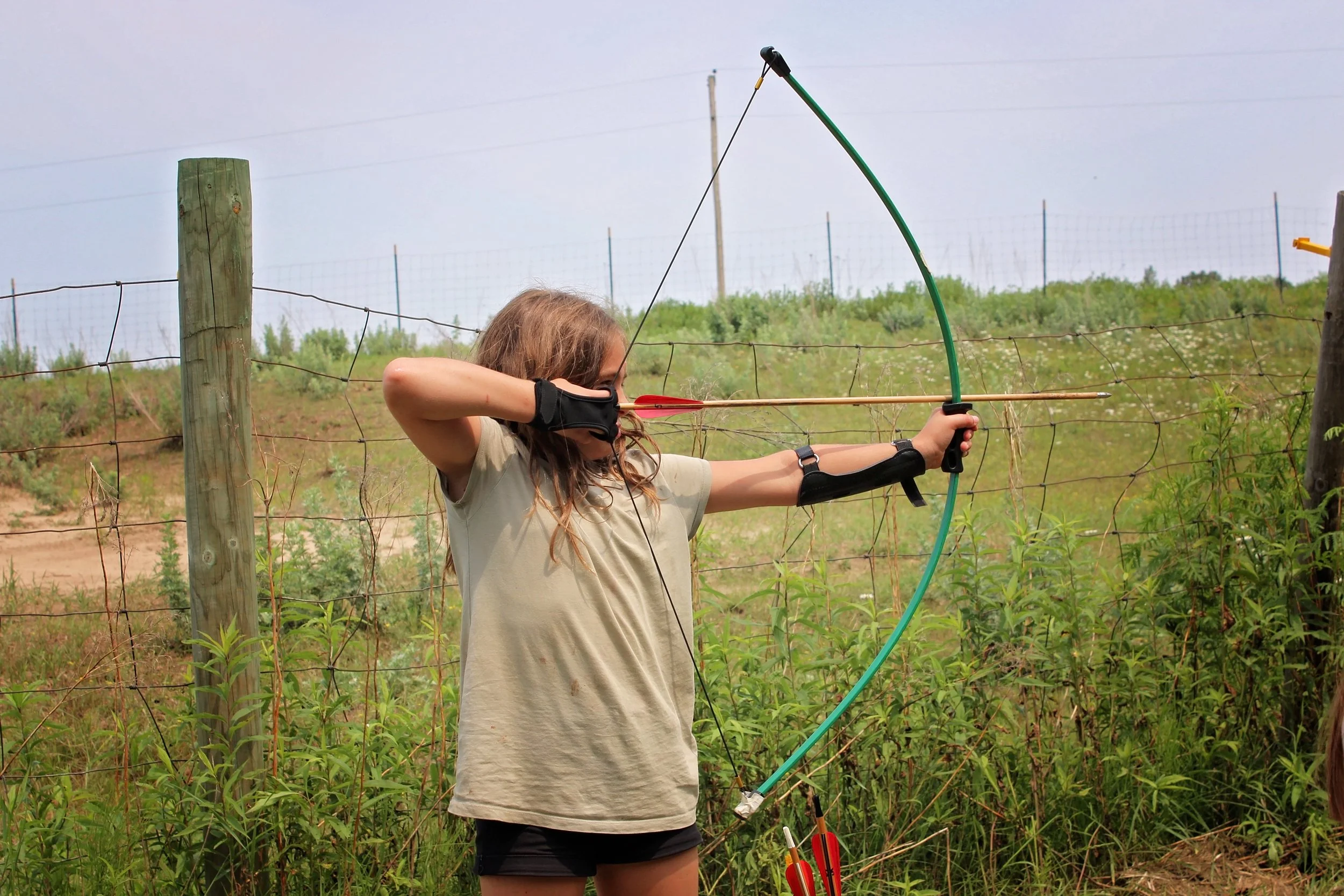 Girl pulling arrow on recurve bow