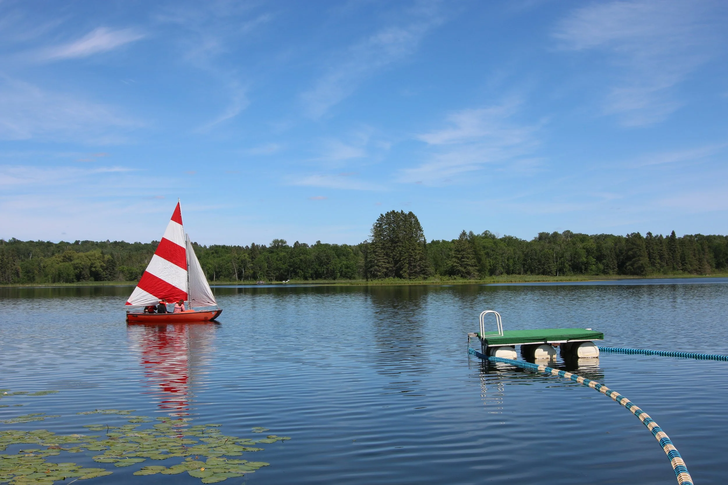 Red boat sailing on lake
