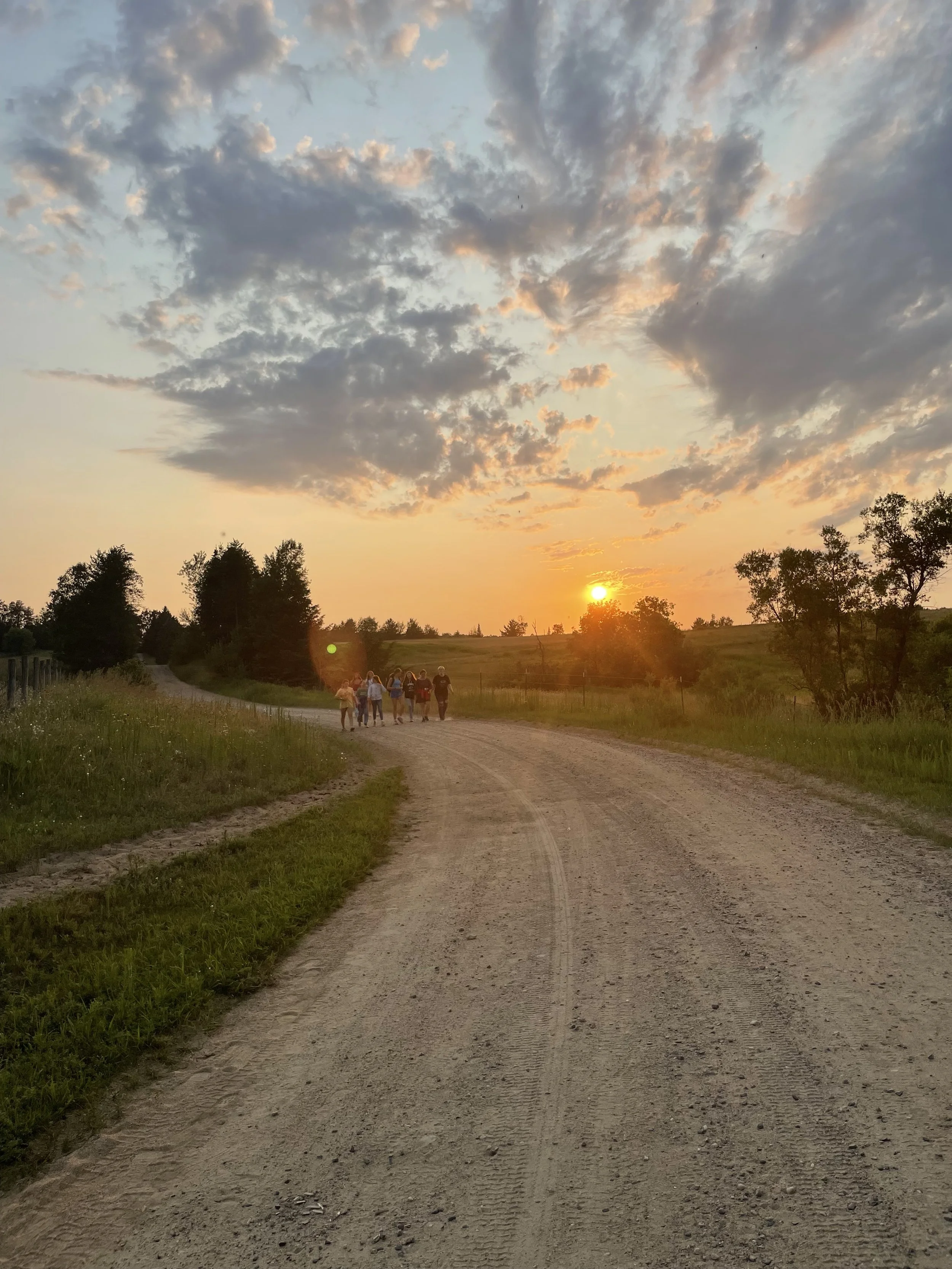 Girls walking down road in sunset