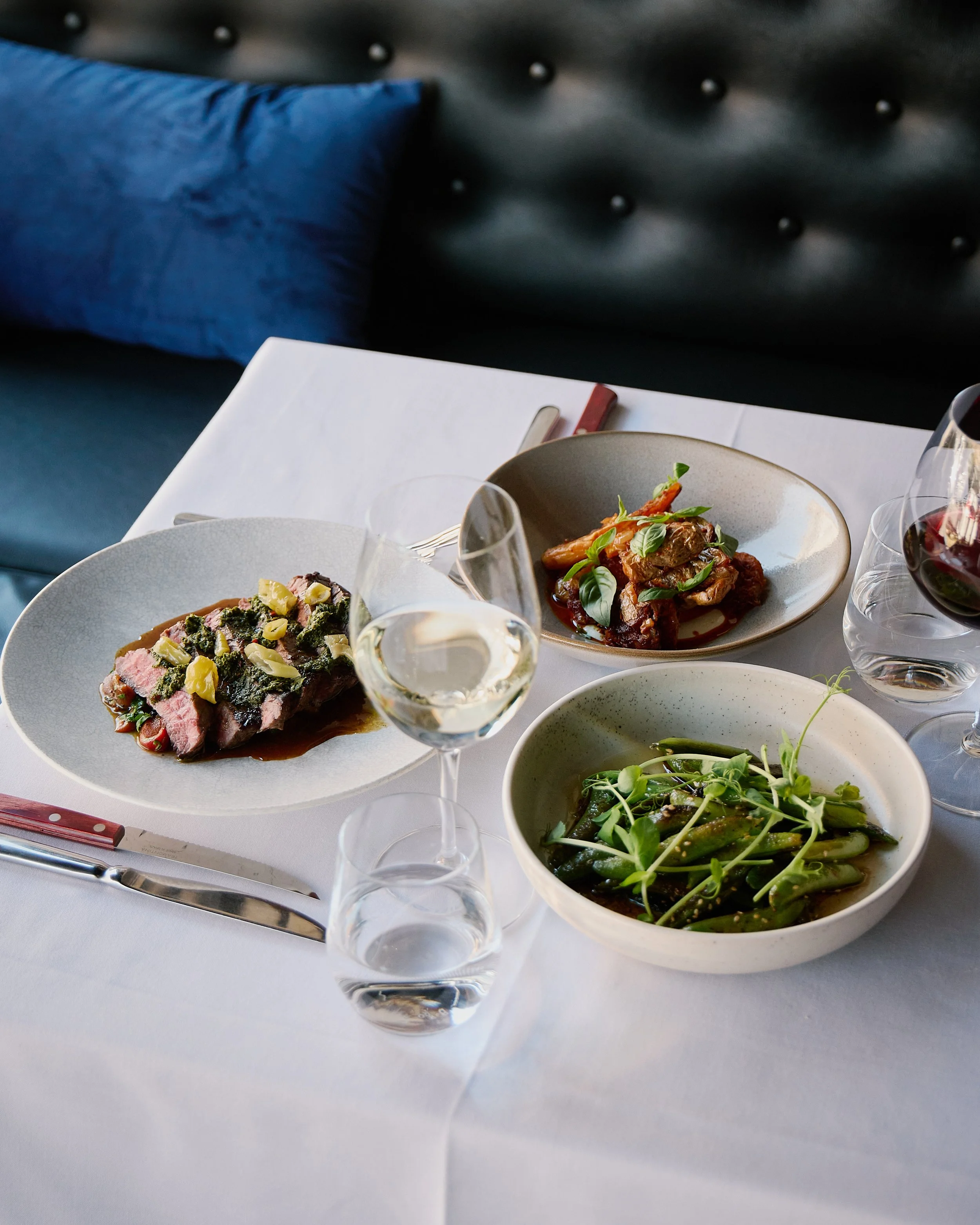 A dining table at Estelle with three plates of food.