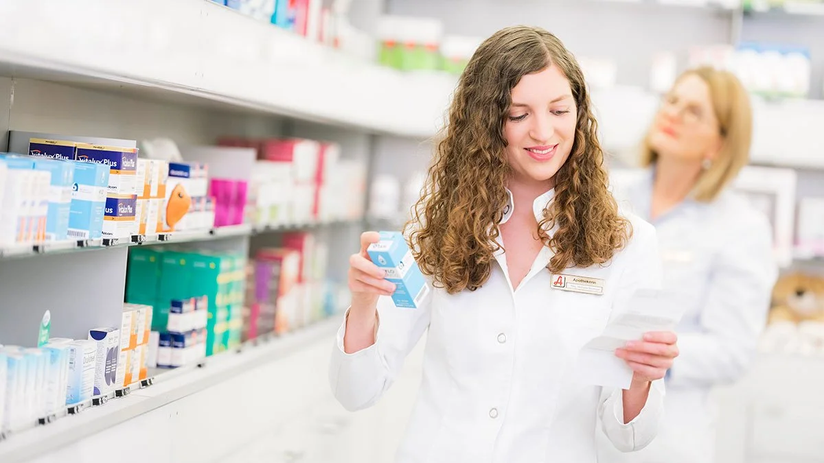 Apothekerin liest eine Packungsbeilage in der Apotheke.