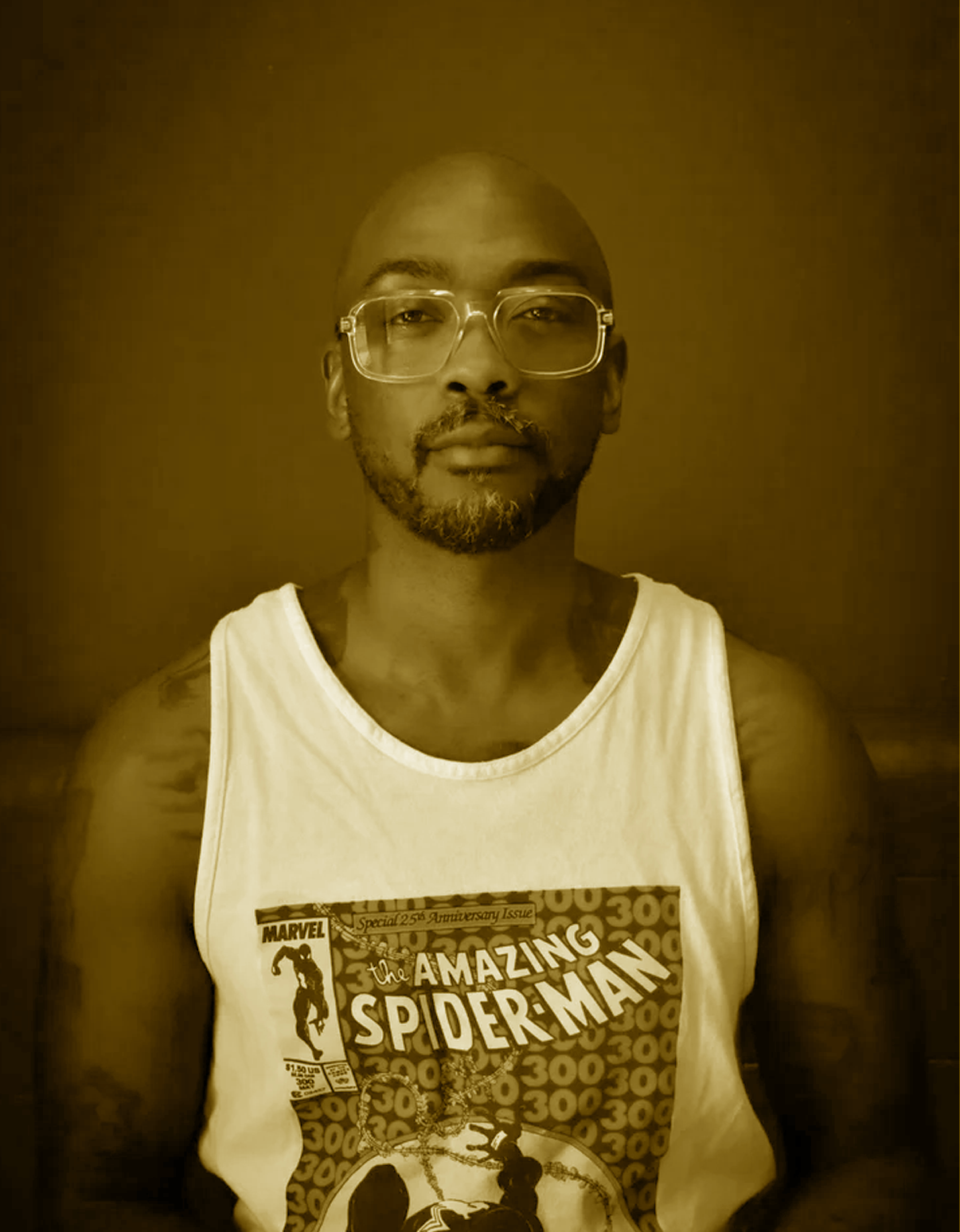 A person with glasses and a beard wearing a white tank top with a Marvel's The Amazing Spider-Man comic book cover.