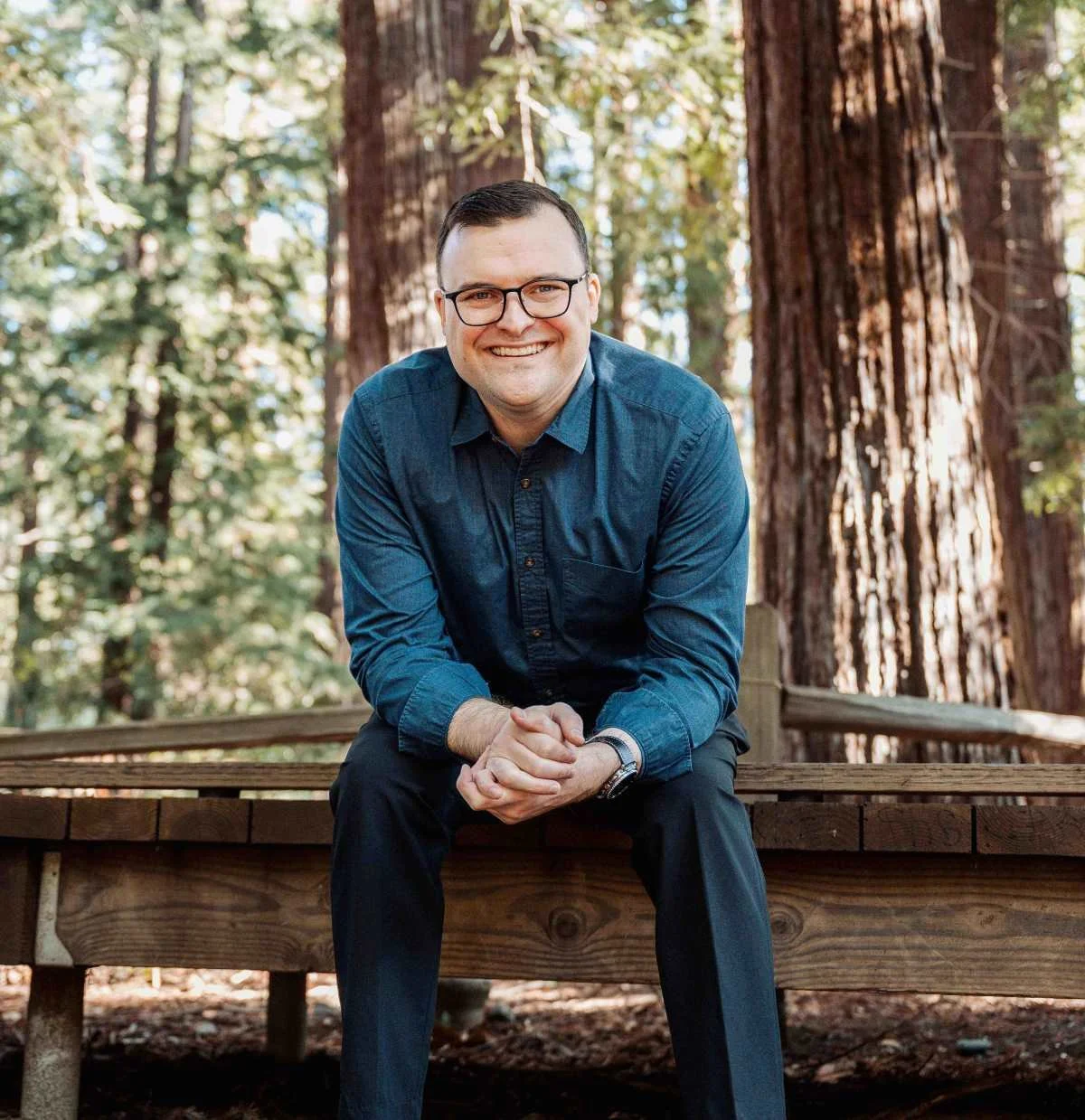 Ryan Thurwachter, LCSW smiling and sitting on a path in the woods
