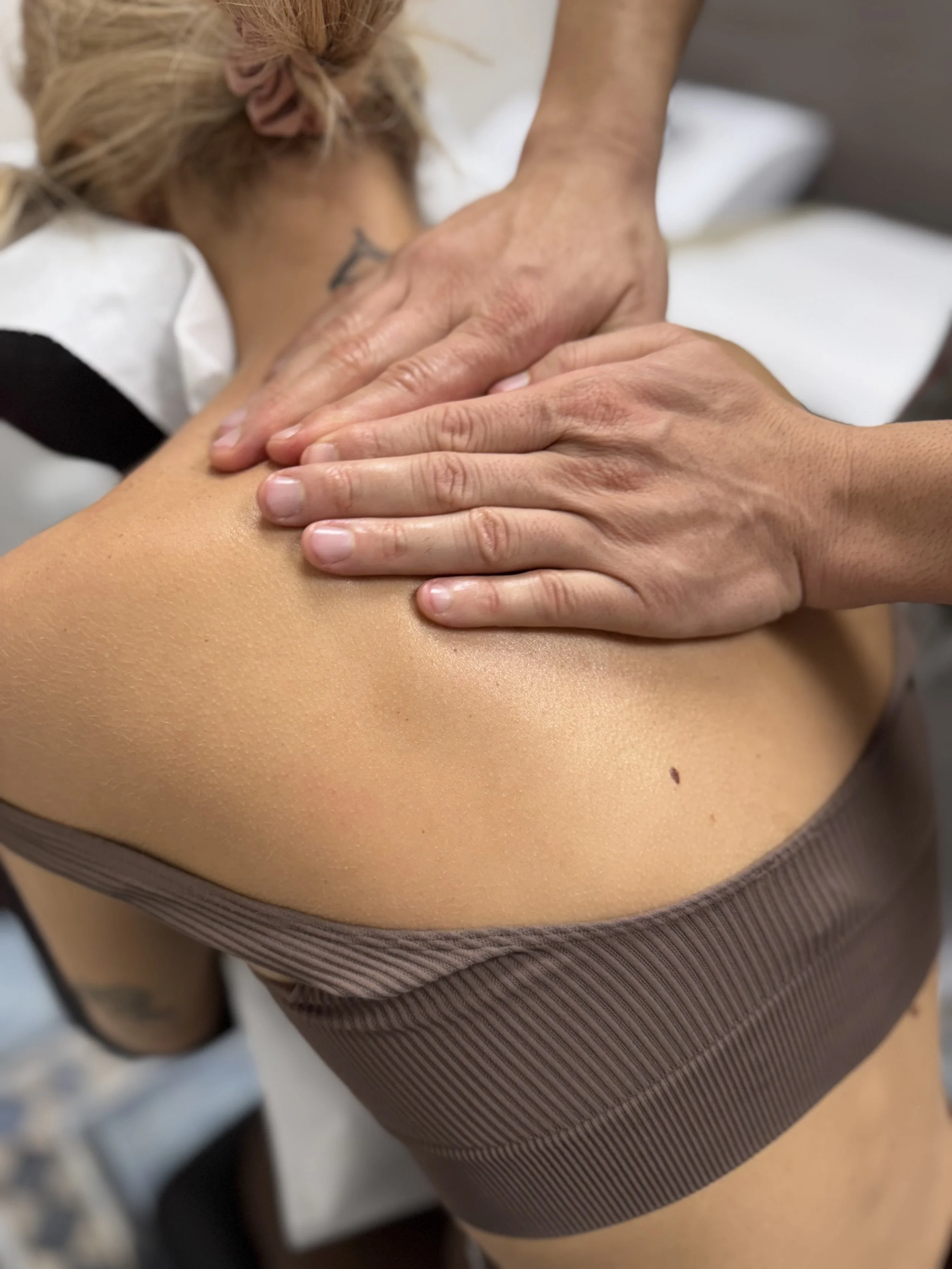 Una persona riceve un massaggio sulla spalla in un ambiente clinico.