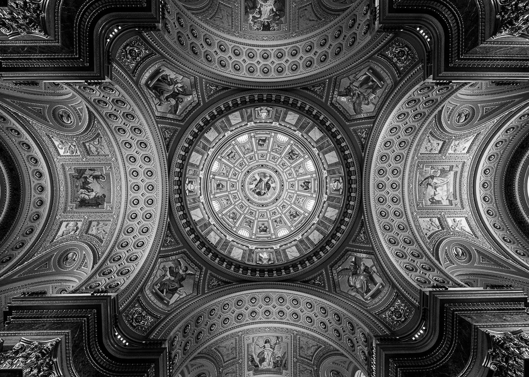 Black and white photo of an ornate domed ceiling with intricate architectural details and religious artwork.