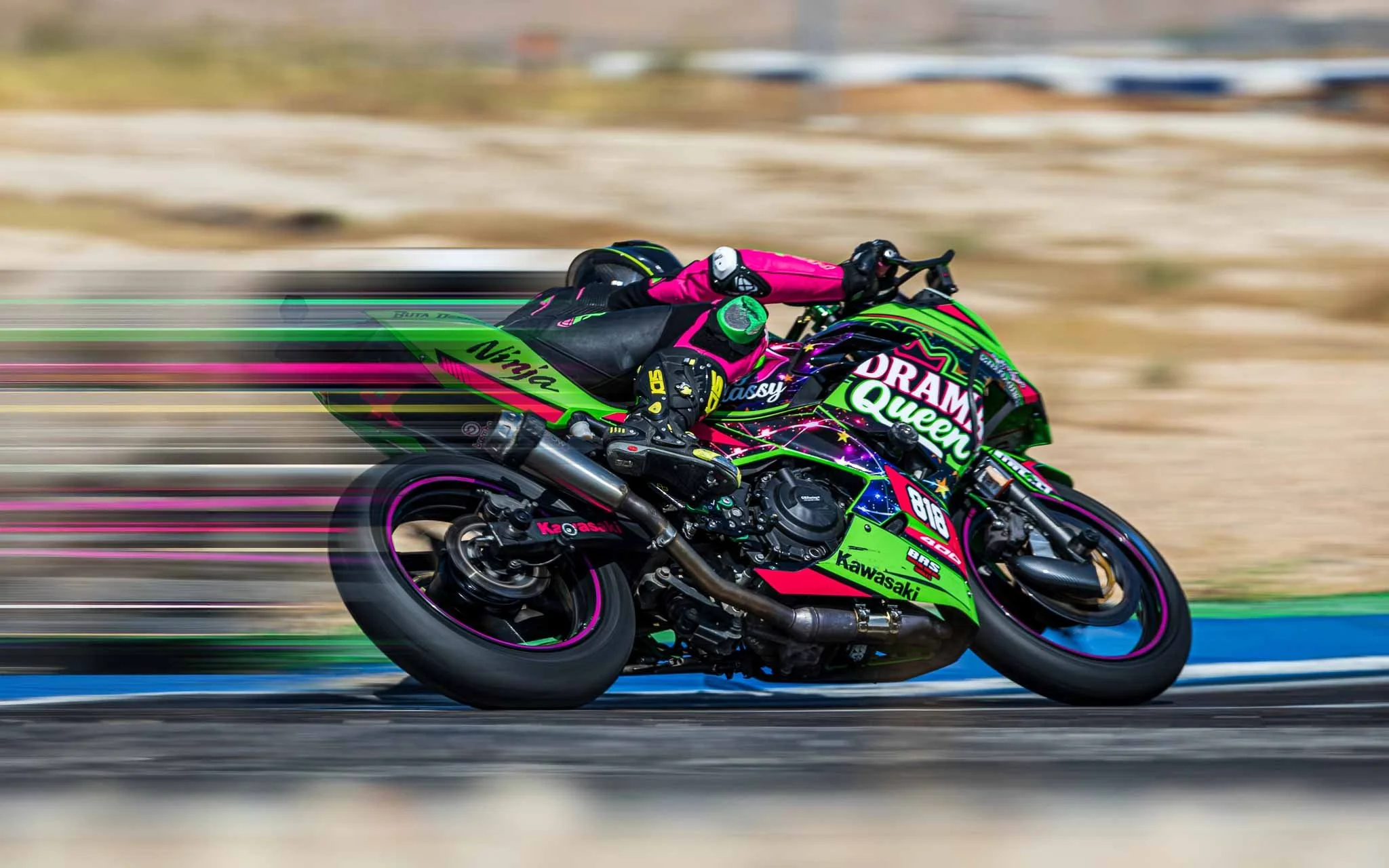Motorcycle racer leaning into a turn on a Kawasaki superbike, with a creative pixel stretch effect emphasizing speed and motion.