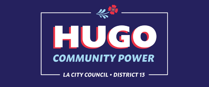 Campaign sign reading "Hugo Community Power, La City Council, District 13" with a decorative flower and leaf design on a dark blue background.