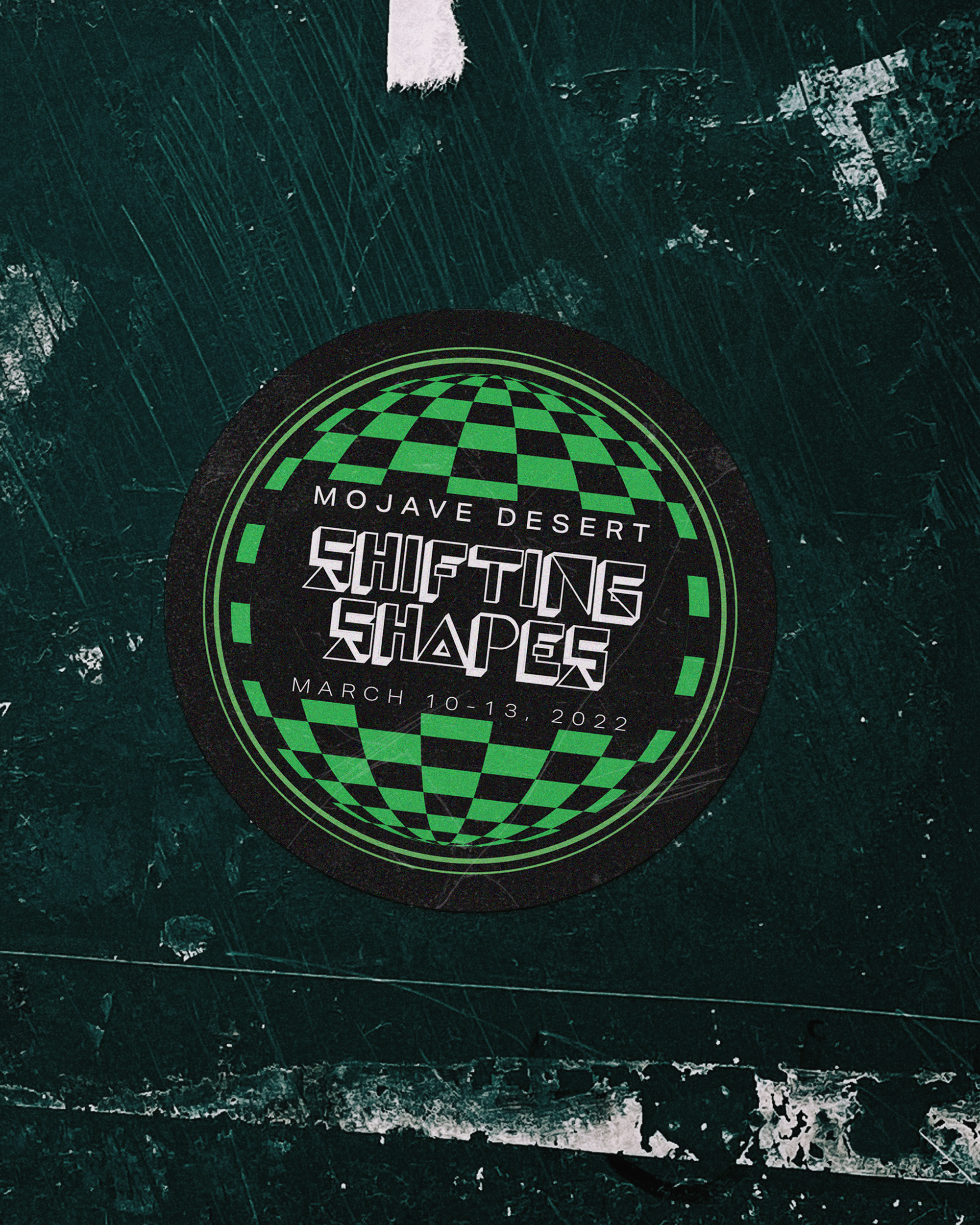 A circular sticker with a black background and green and white geometric graphics promoting the Mojave Desert Shifting Shapes event, held from March 10-13, 2022.