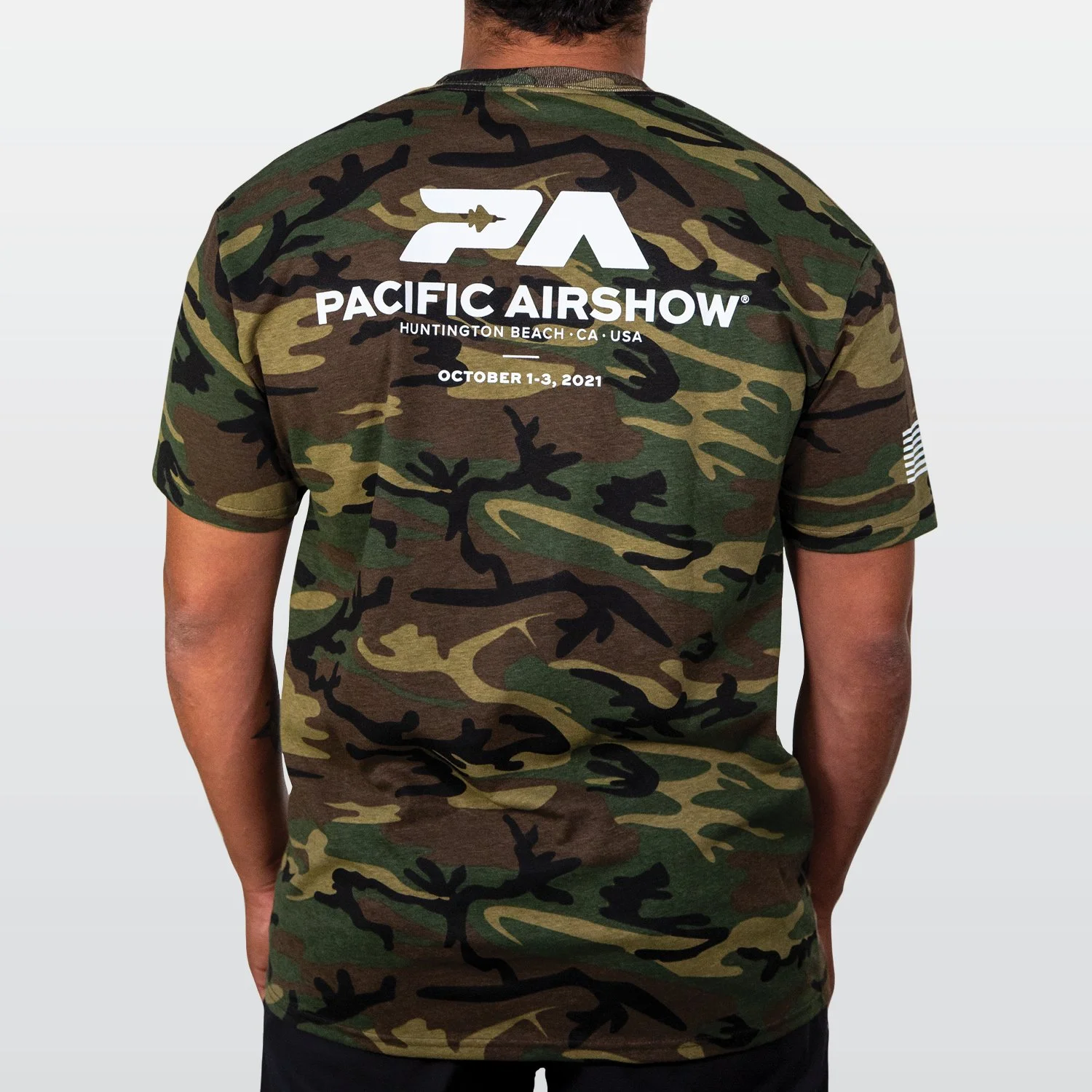 Back of a man wearing a camouflage T-shirt with the 'Pacific Airshow' logo and event details on it.