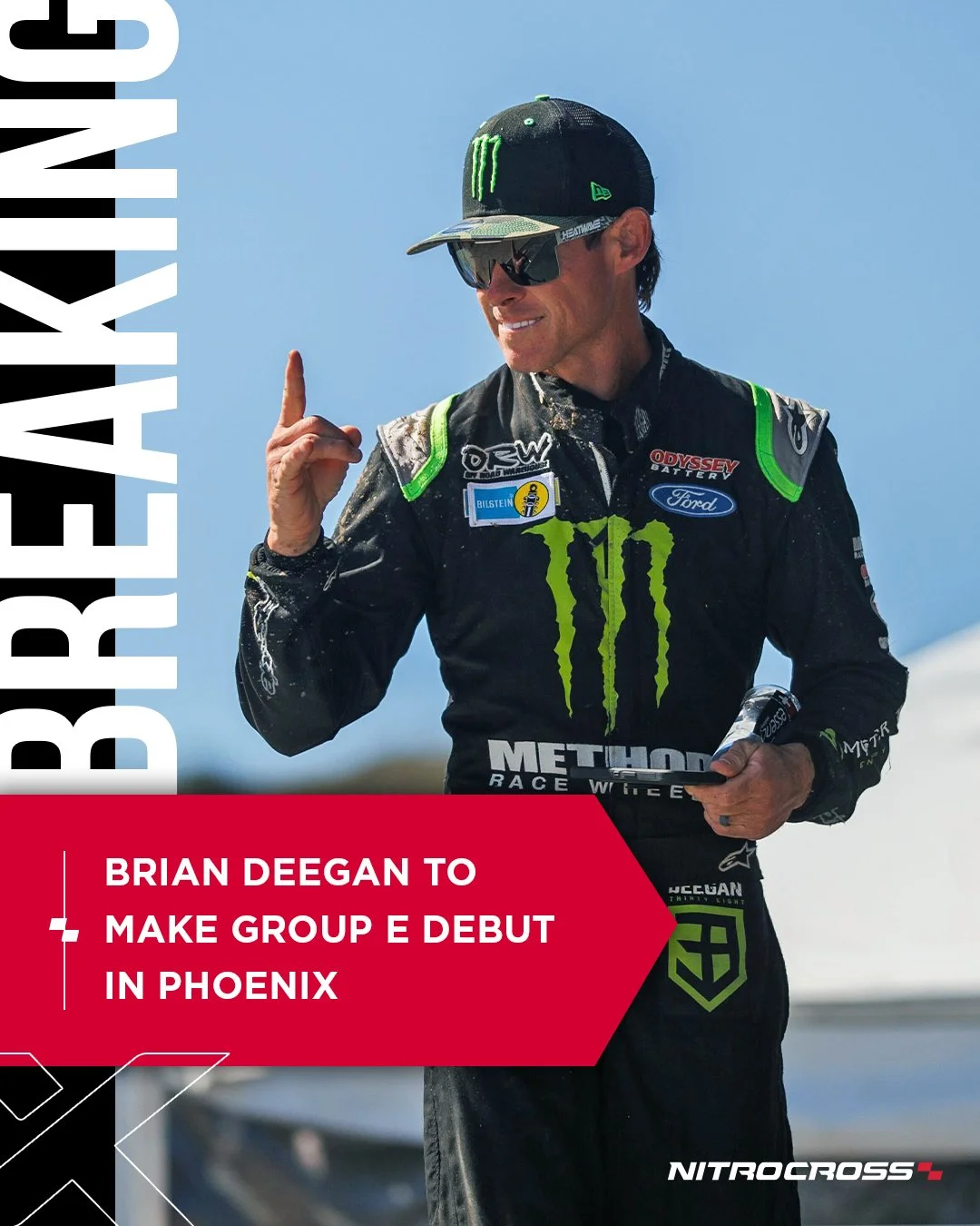 A man in a racing suit, wearing sunglasses and a cap with Monster Energy logo, points upward while holding a phone, against a blue sky background. The image has a red banner with text about Brian Deegan making his debut in Phoenix for Group E.