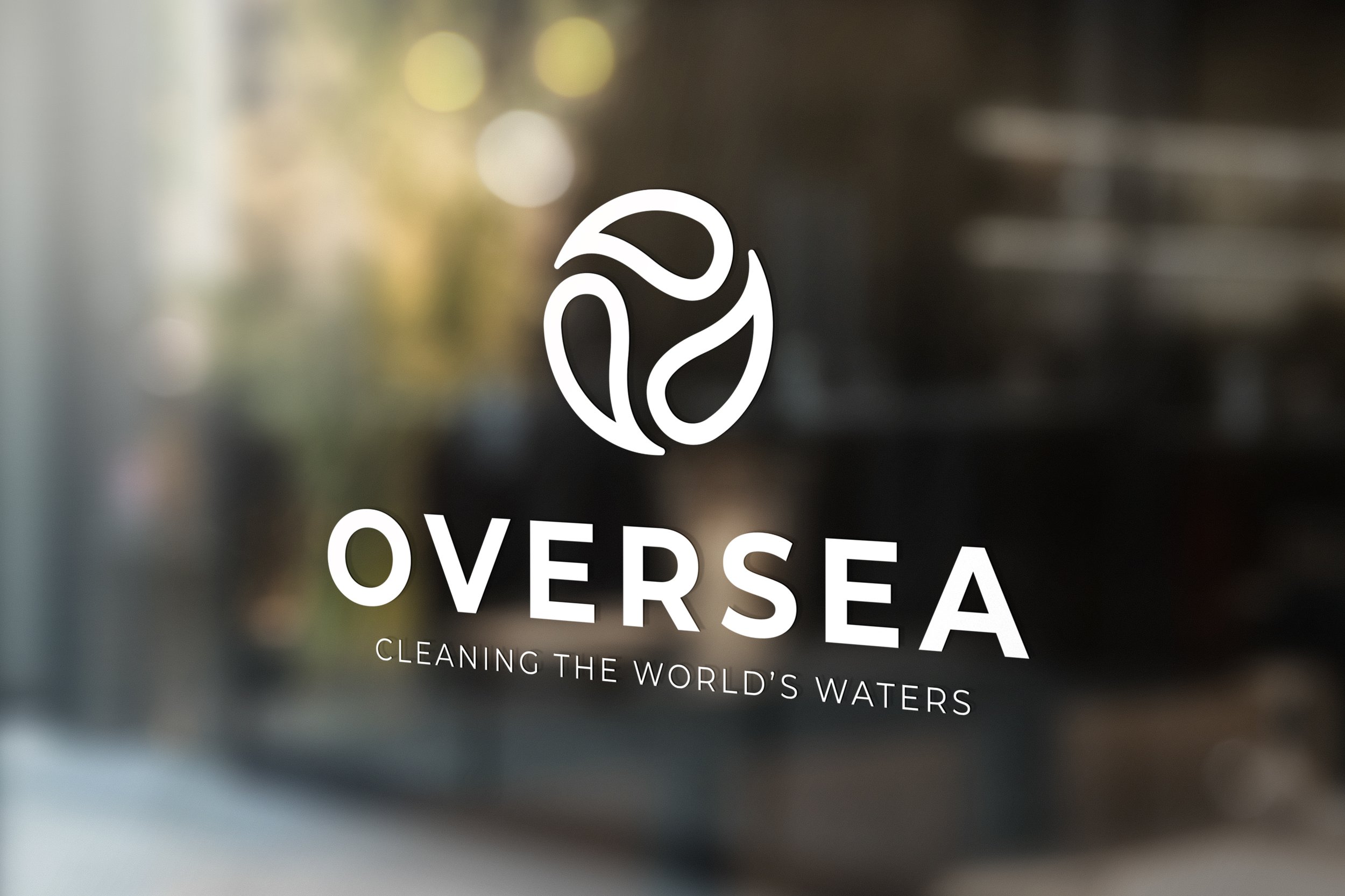 Logo of OVERSEA with a circular design and the tagline 'Cleaning the World's Waters' displayed on a blurred background.