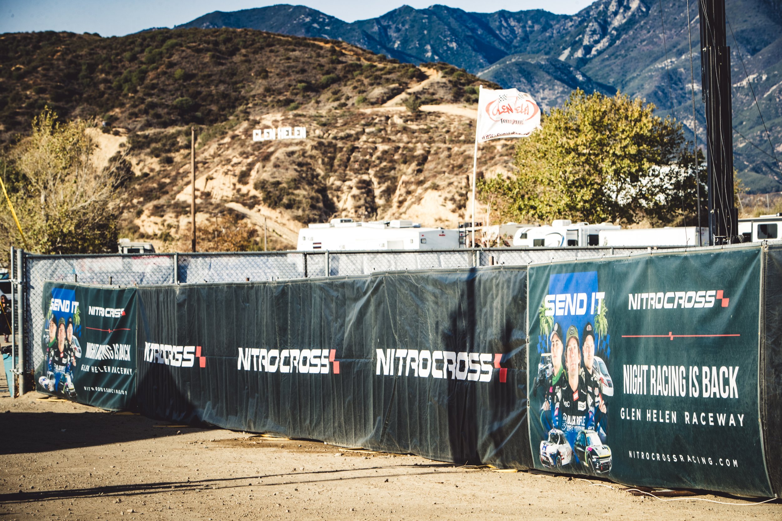 Banner advertising NitroCross night racing event at Glen Helen Raceway, with mountains in the background