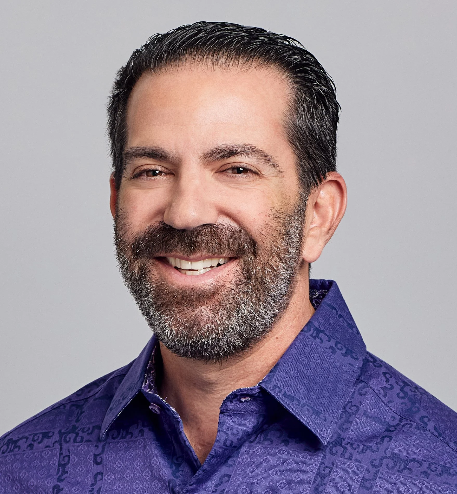 Justin Grossman, founder of Practice Self and Conscious Leadership Coach, smiling in a purple patterned shirt