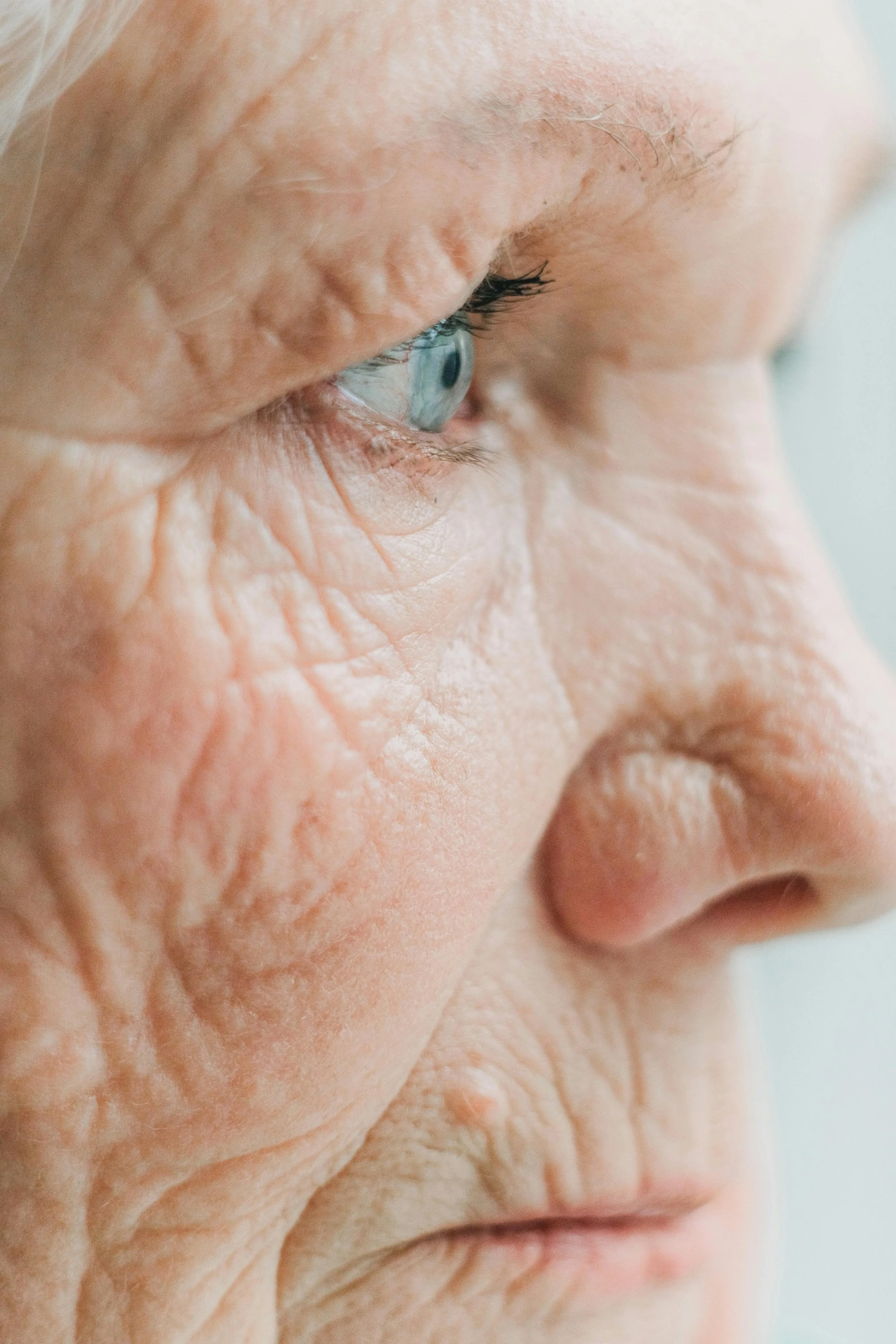 Close-up of an elderly person's face focusing on the eye and surrounding wrinkles.