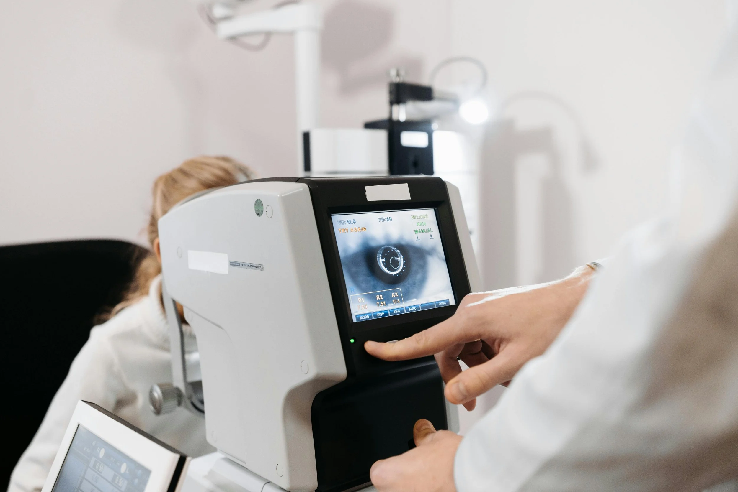 A healthcare professional using an eye examination machine to perform a vision test on a patient.