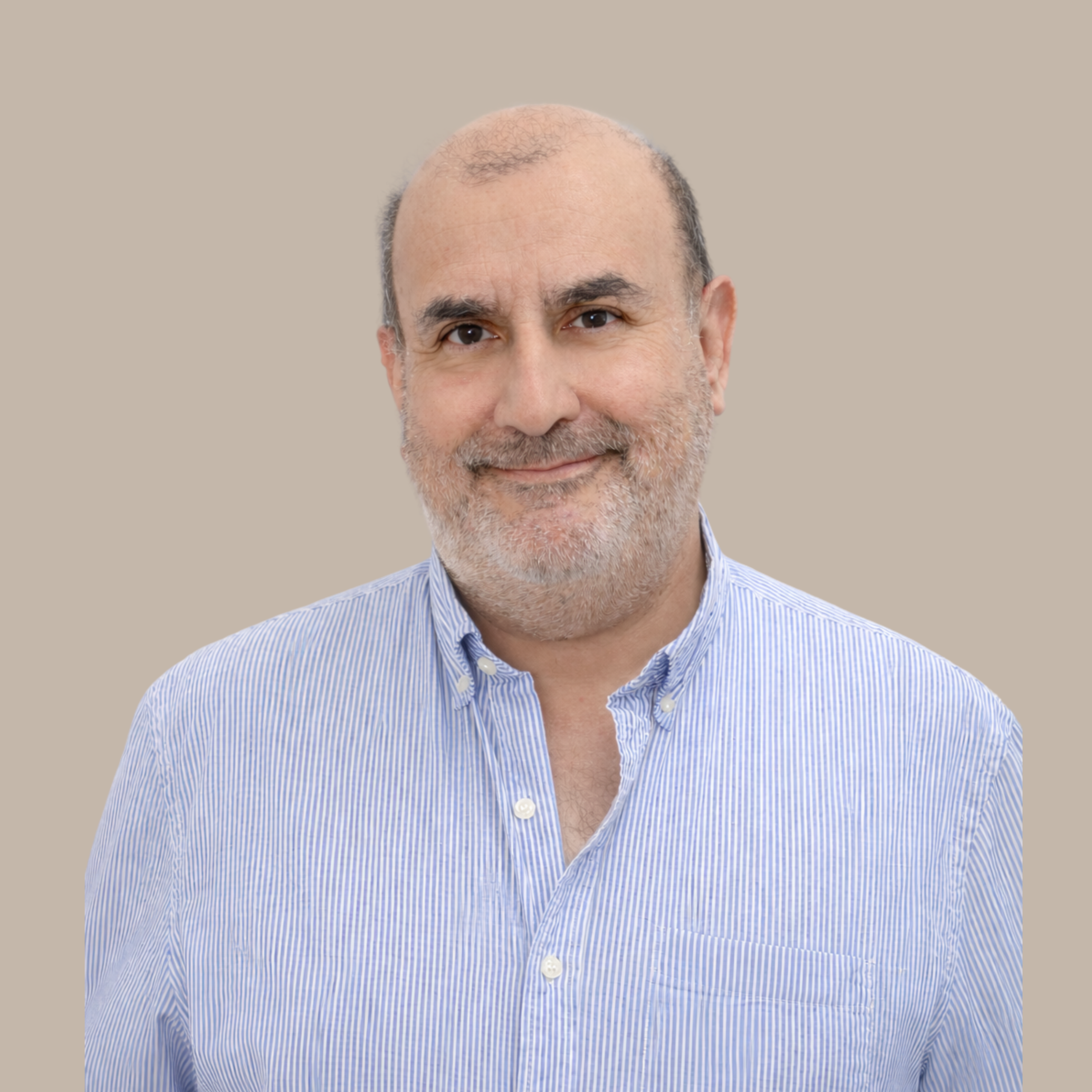 A middle-aged man with a beard and receding hairline wearing a light blue striped button-up shirt, smiling against a beige background.