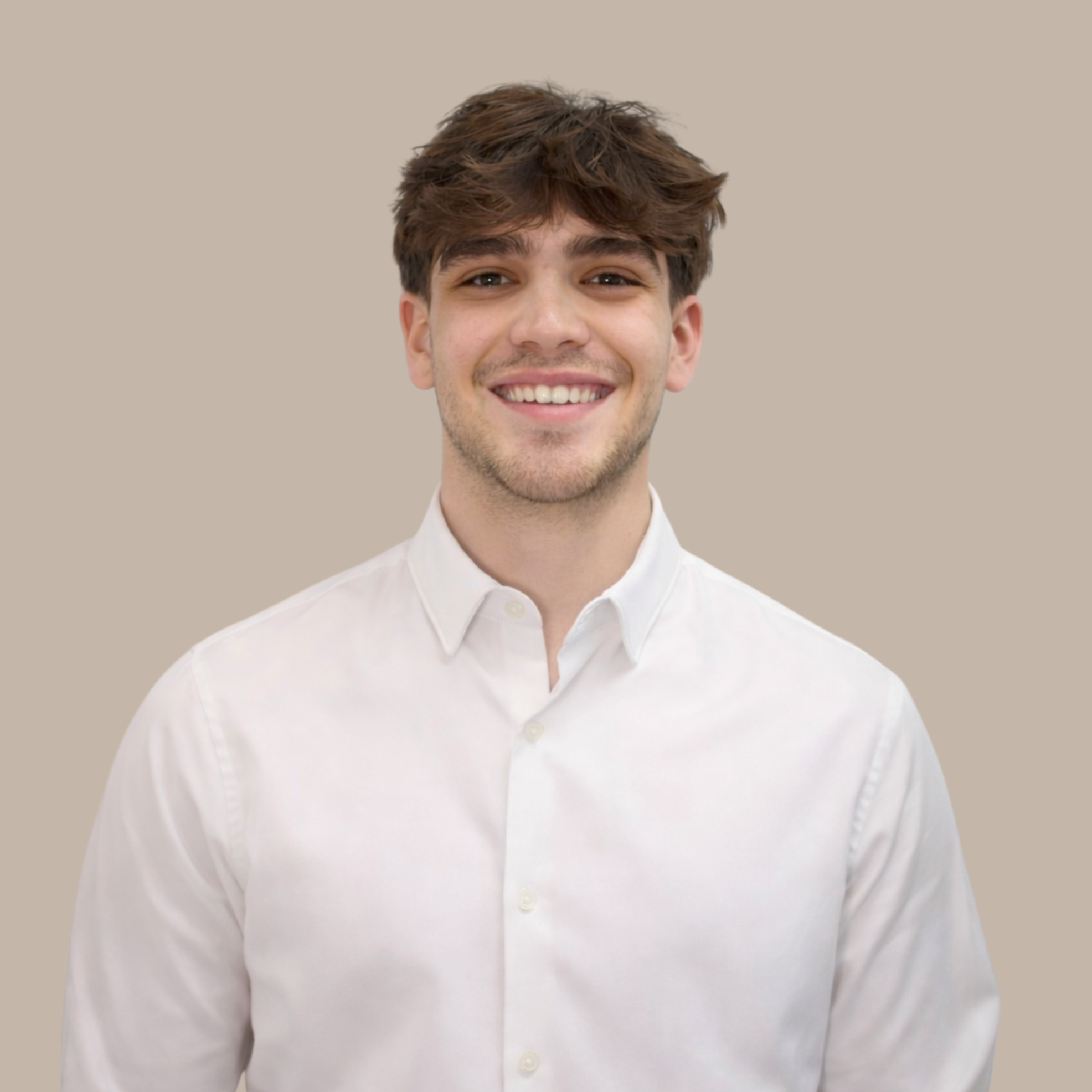 A young man with brown hair smiling, wearing a white button-up shirt, standing against a beige background.