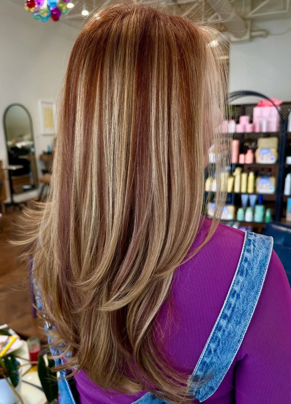 Long, layered hair seen from behind, with blonde ribbons over a copper-red base