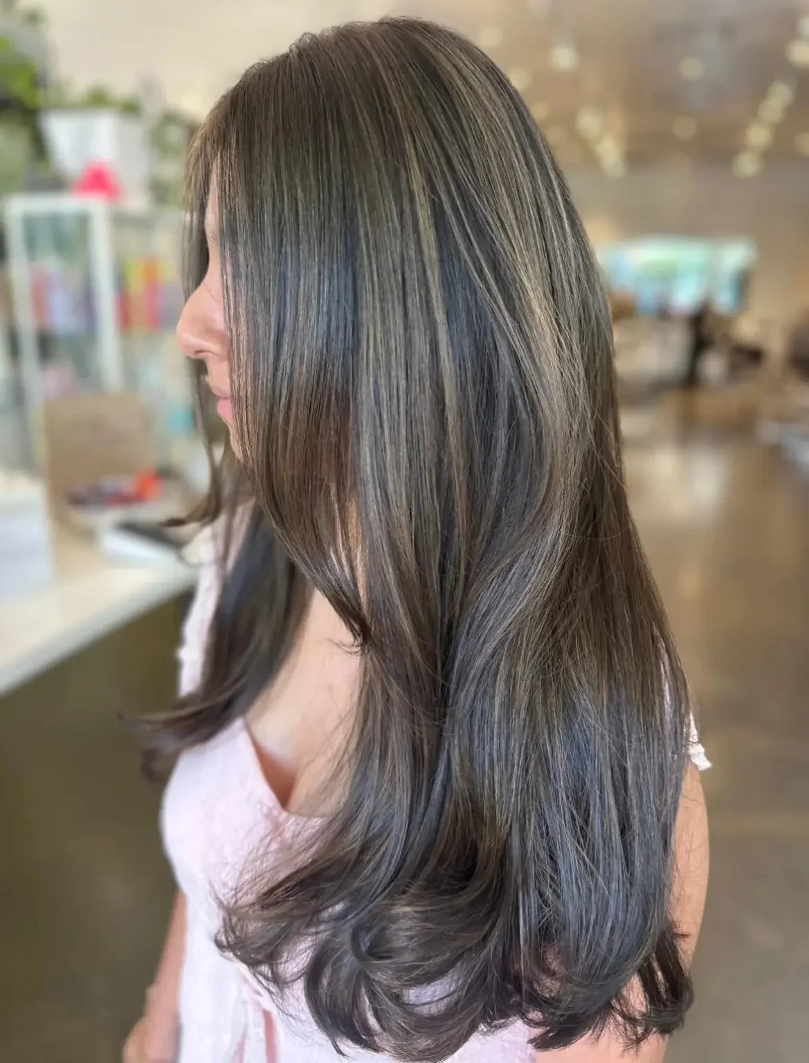 Long, smooth brunette hair with soft dimension and a polished bend at the ends, seen from the side