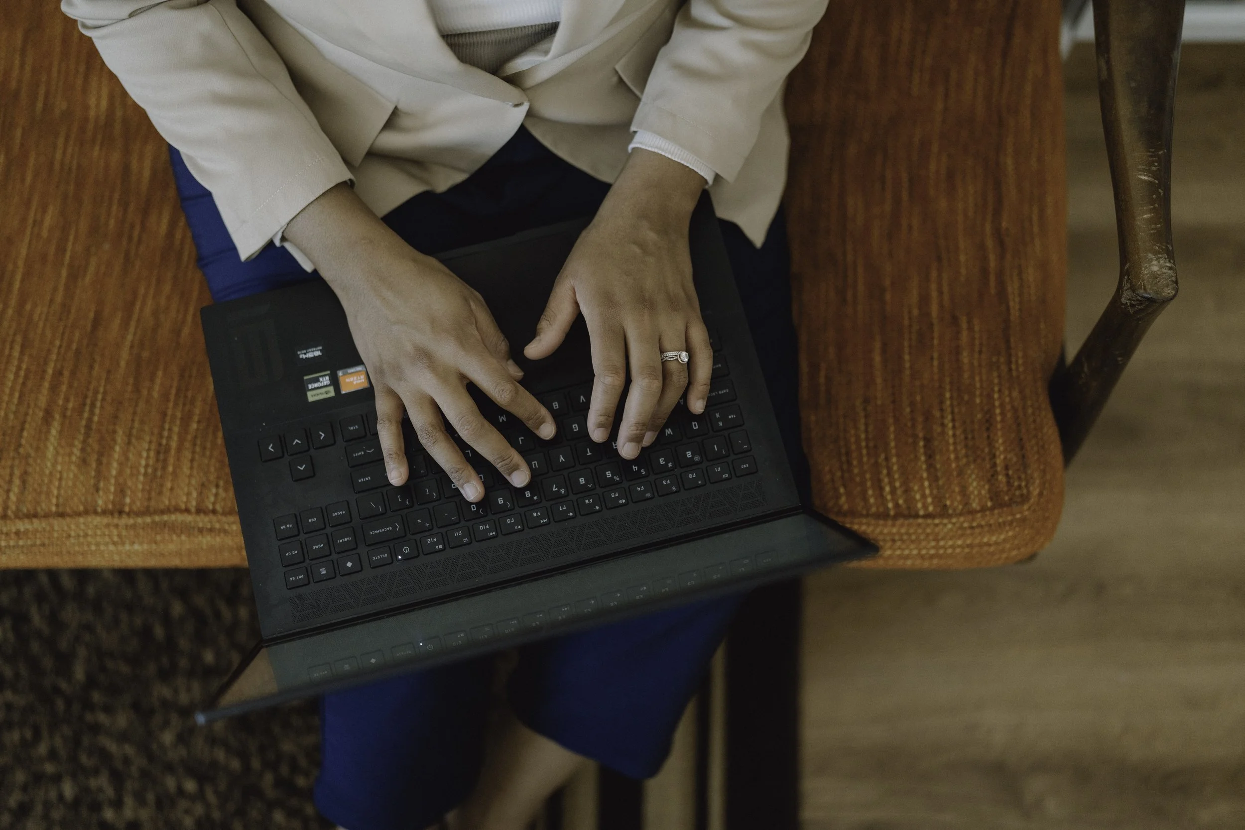 Therapist typing on a laptop during a telehealth call with clients