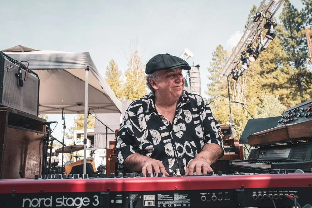 Keyboardist smiling behind a Nord