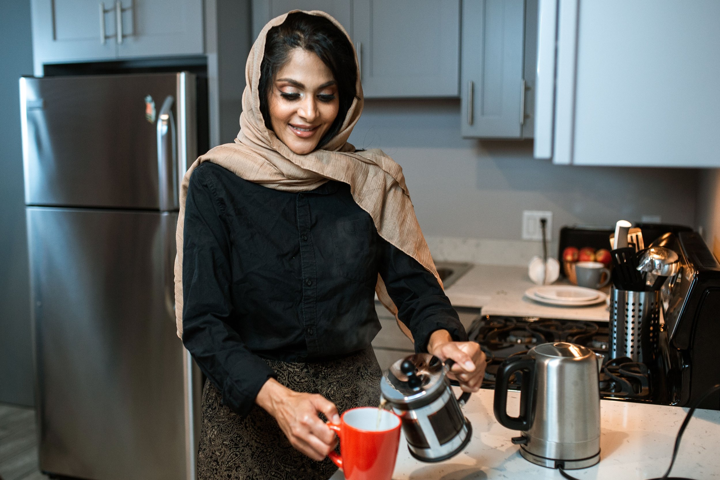 muslim woman wearing hijab pouring coffee | The Sectional