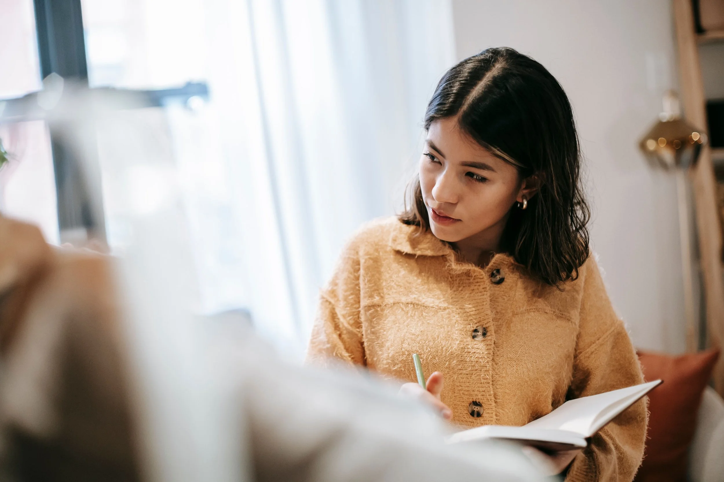 woman writing in journal in fall | The Sectional