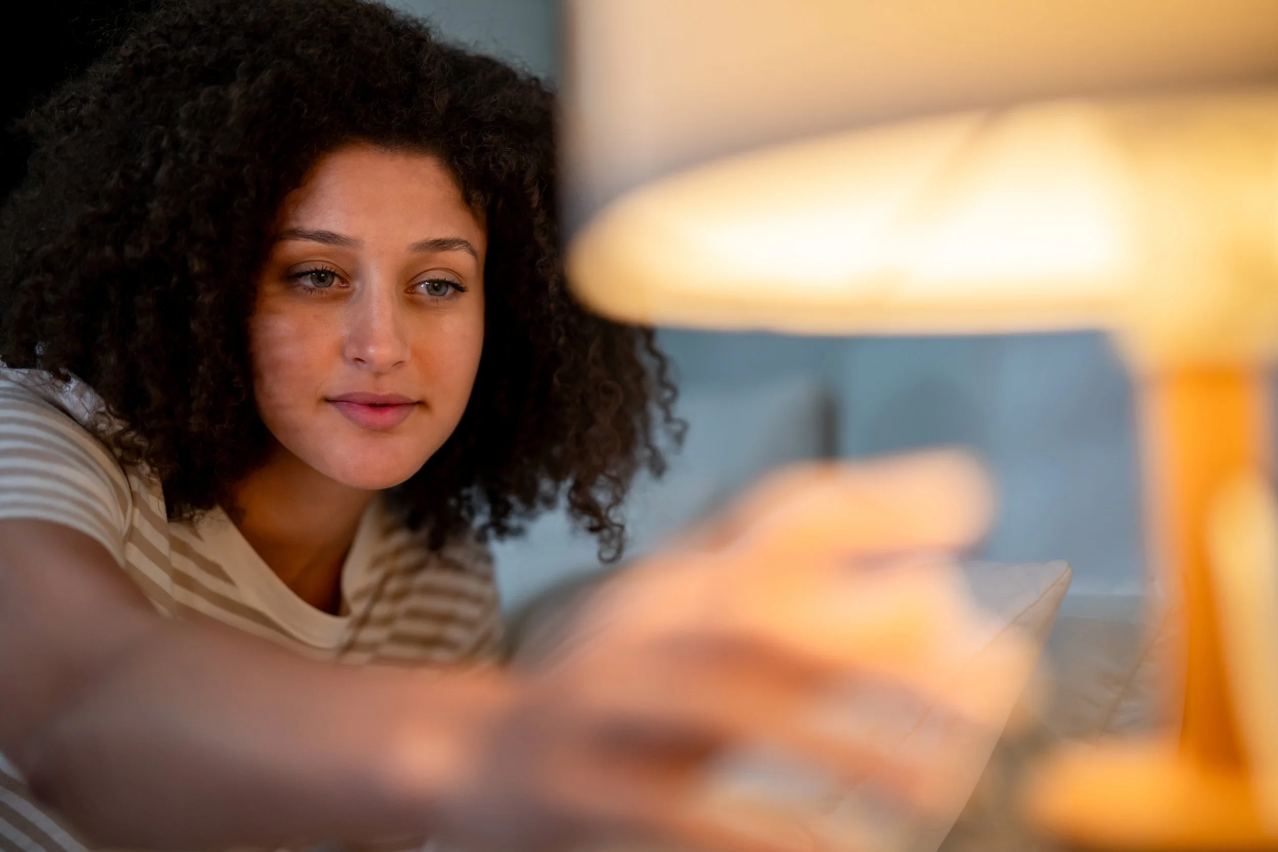 woman in bed turning the light off on nightstand