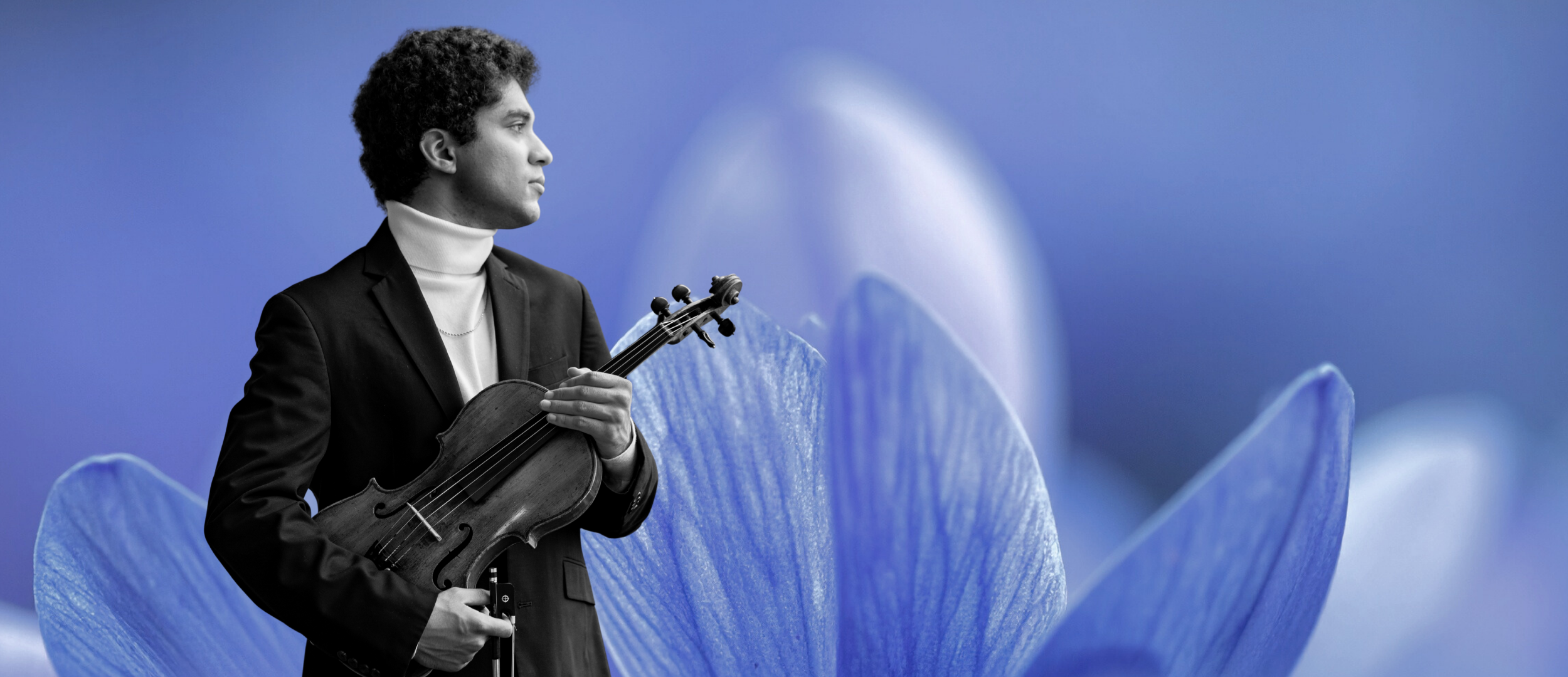 A black and white photo of a young man holding a violin, set against a background of blue flower petals.