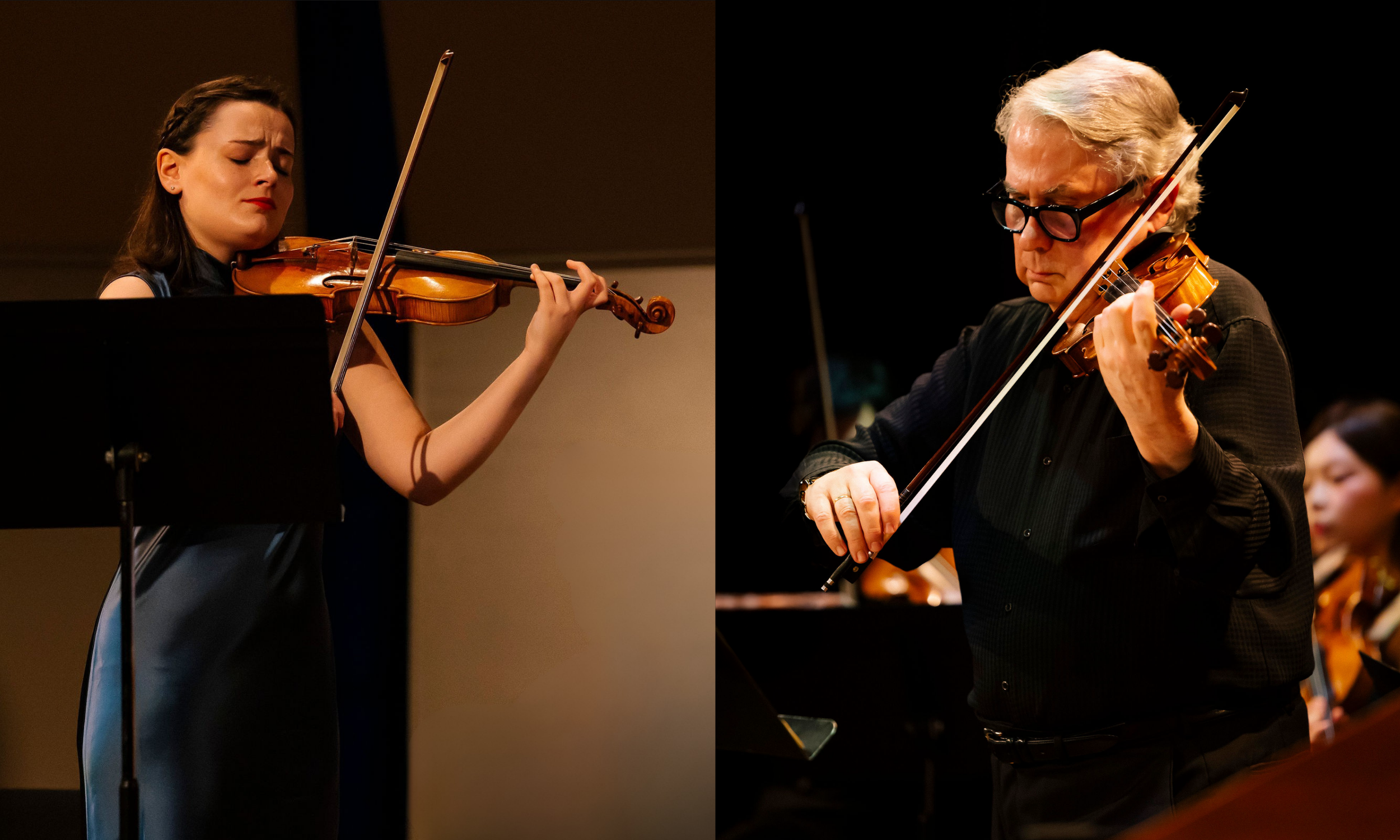 Two musicians playing violins on stage during a performance, a woman on the left and a man on the right.
