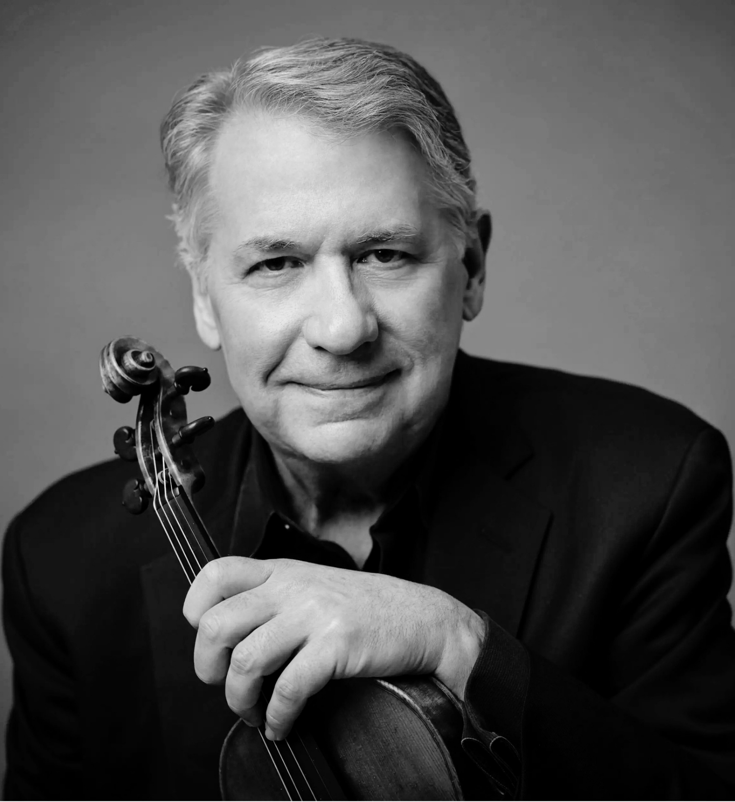 Black and white portrait of a smiling man, Philip Setzer, with gray hair, holding a violin.