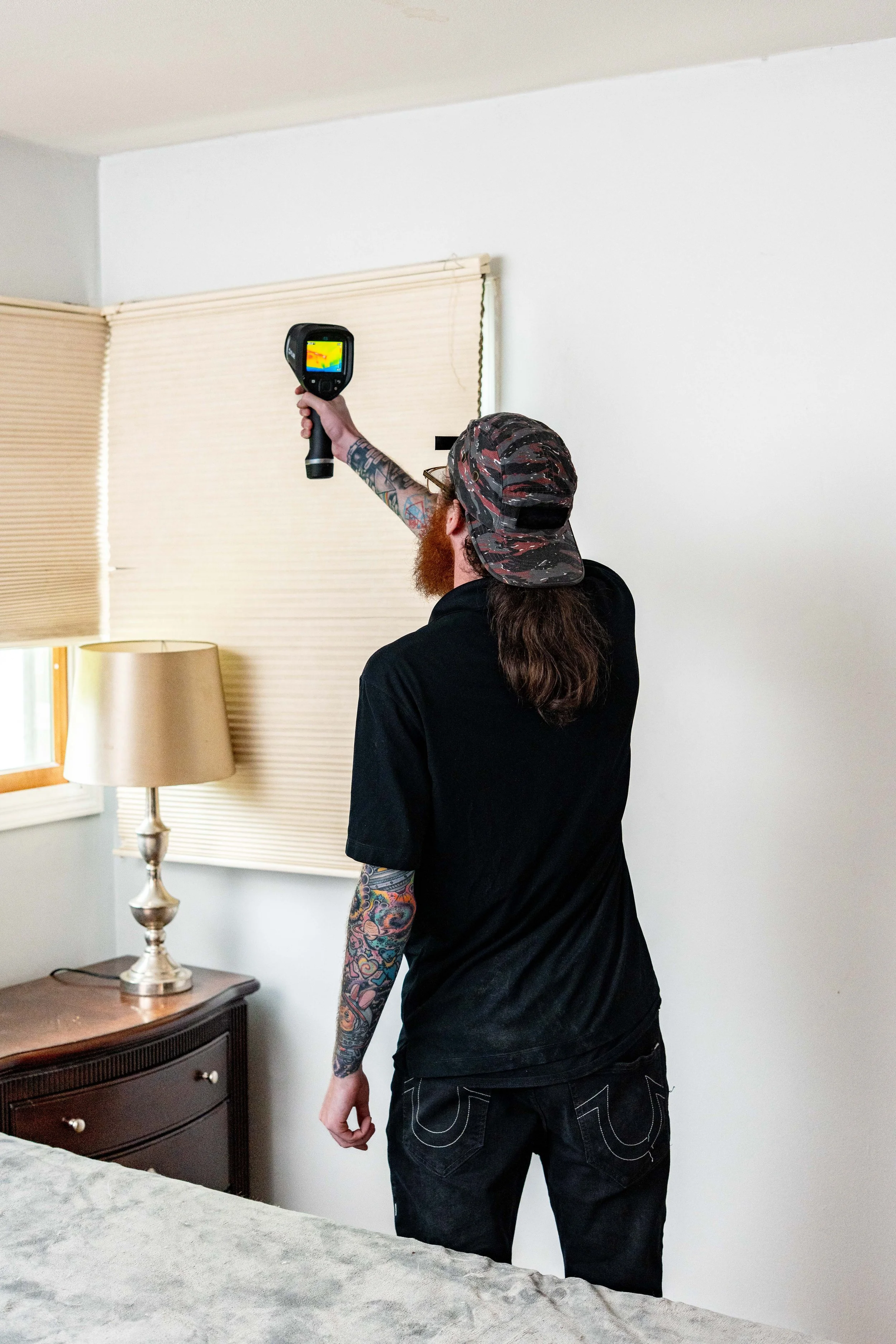 Home Efficiency Experts employee holding a thermal imaging camera during a home energy assessment