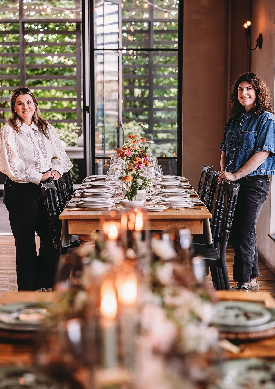Lexi Dahlin and Katie Zahniser, Co-Owners of Beyond Tablescapes stand on either side of a styled tablescape.