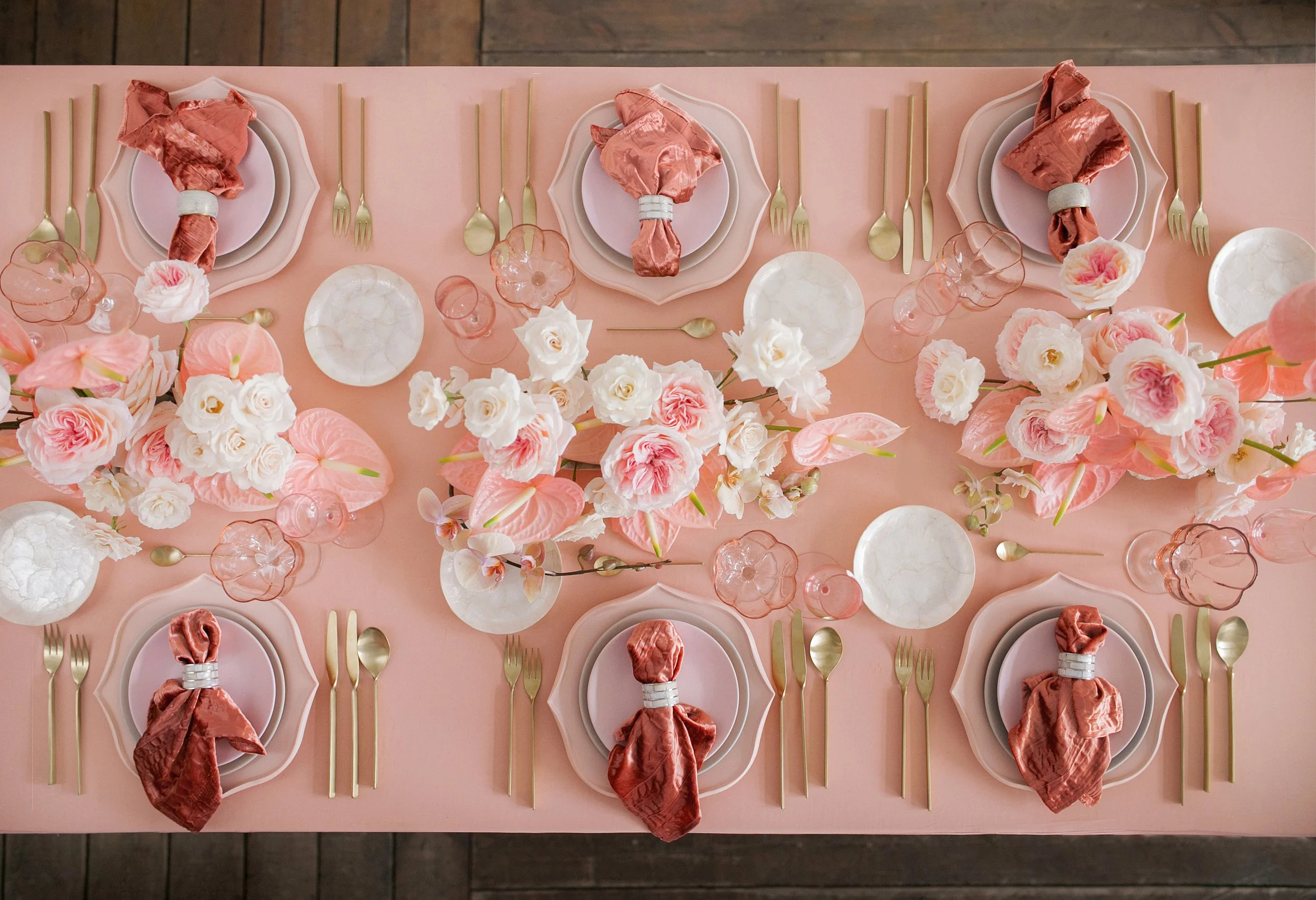 Event Rental, Tablescape, Main Line PA, Chester County, PA, Bucks County PA, Montgomery County PA, Delaware County, PA, Philadelphia.A pink table setting with floral arrangements, gold cutlery, and pink napkins.